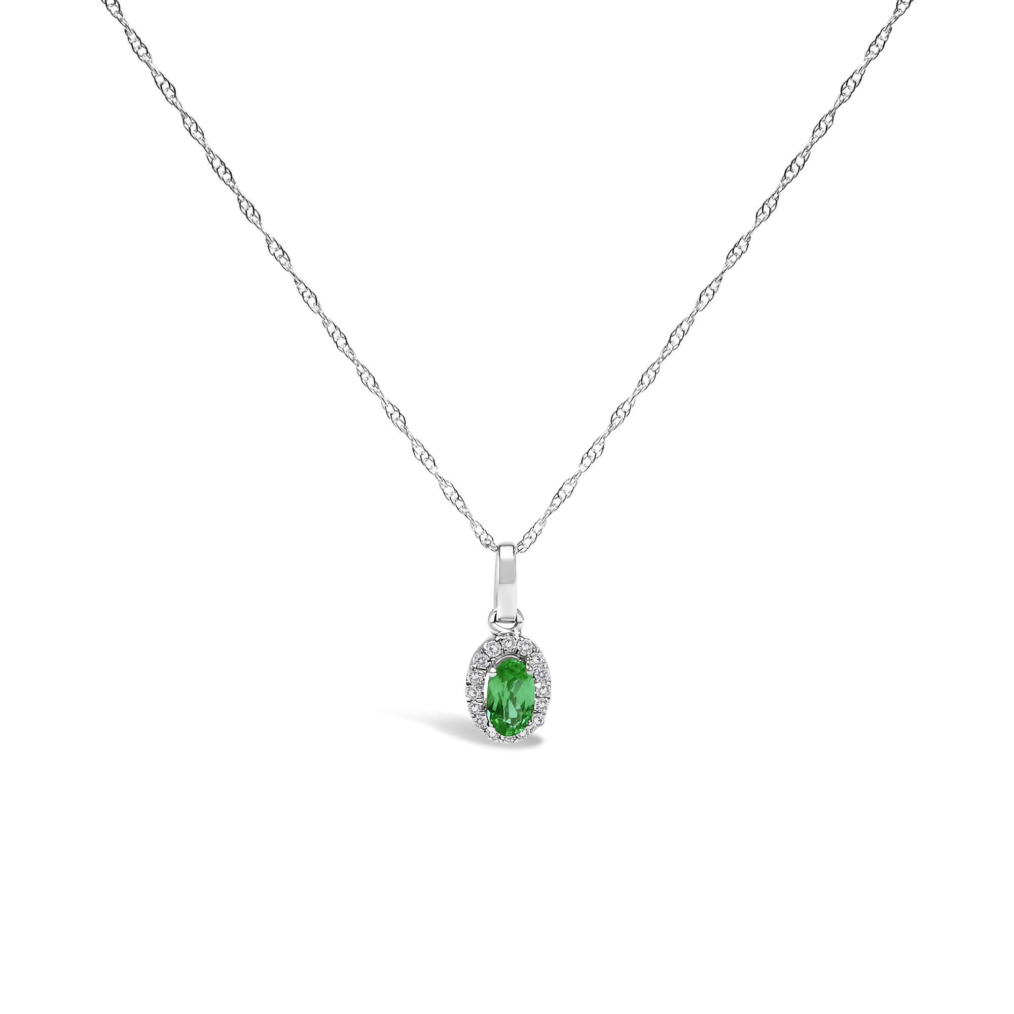 Racchiudendo con eleganza l'essenza della grazia, questa collana in oro bianco 10K placcato rodio ha come cuore un affascinante smeraldo verde di forma ovale. Di provenienza naturale e con un trattamento del colore migliorato, le tonalità rosso