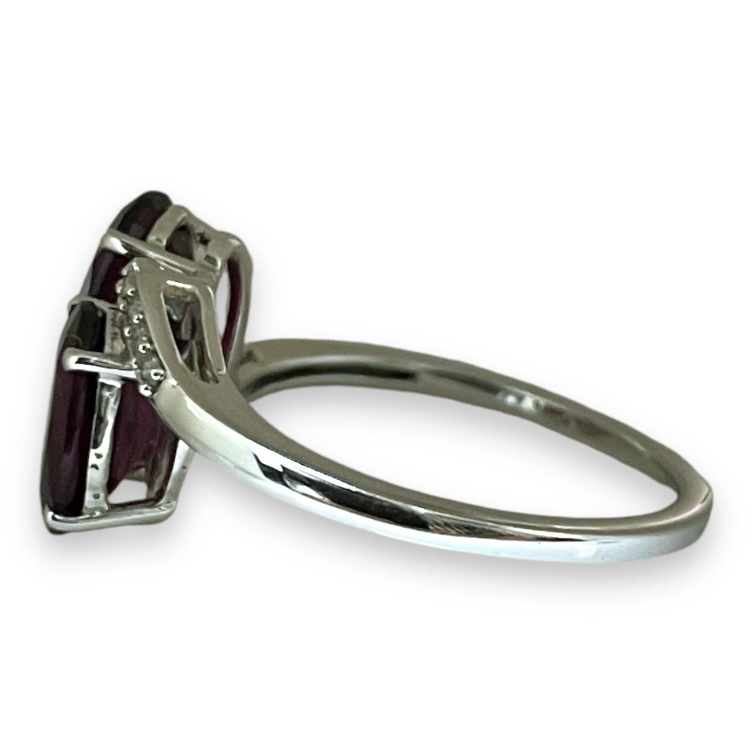 This luxurious garnet ring exudes elegance with its deep, dual garnet stones perfectly set in polished white gold. The rich red hues of the garnets contrast beautifully with a delicate row of shimmering diamonds, creating a refined and timeless