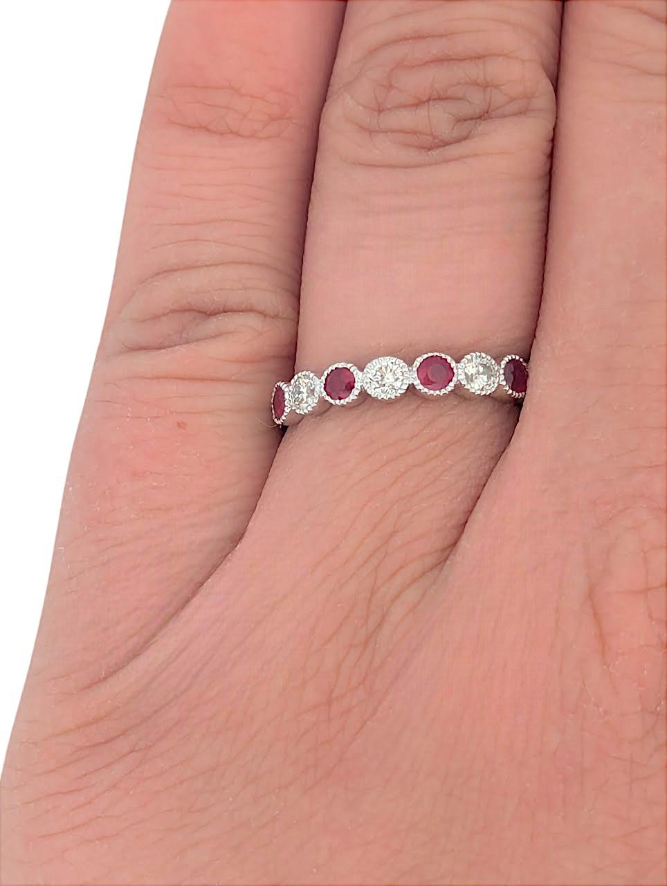 Timeless and elegant, this 10K white gold band features 0.40 CTW of natural rubies set in secure bezel settings, complemented by 0.25 CTW of sparkling natural diamonds. The intricate milgrain detailing adds a vintage touch, making this ring a