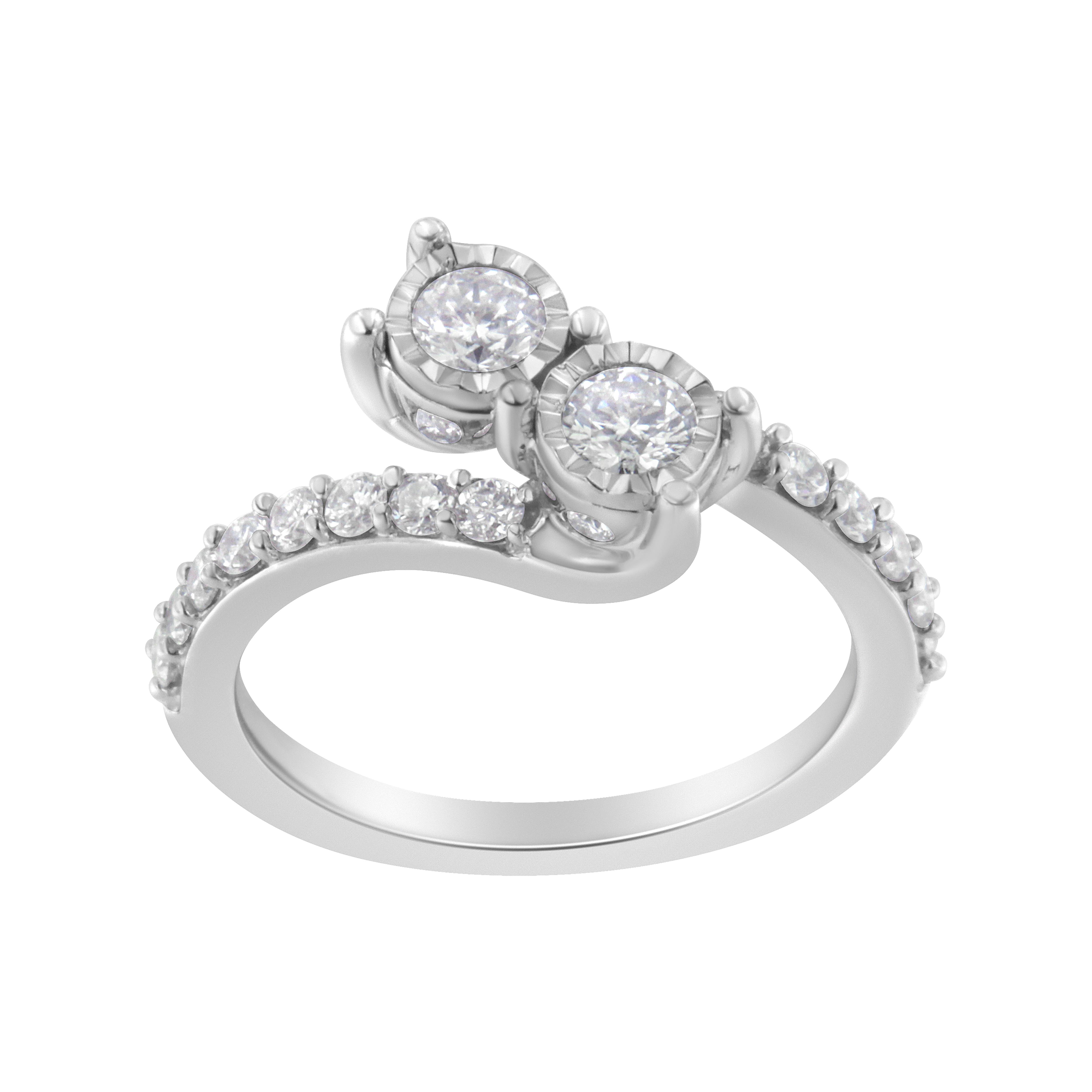 Celebra vuestra vida en común con este exquisito anillo de diamantes de dos piedras. Realizado en oro blanco de 10 quilates, este diseño exquisitamente elaborado presenta dos diamantes de 1/5 quilates engastados en baño milagroso, que representan