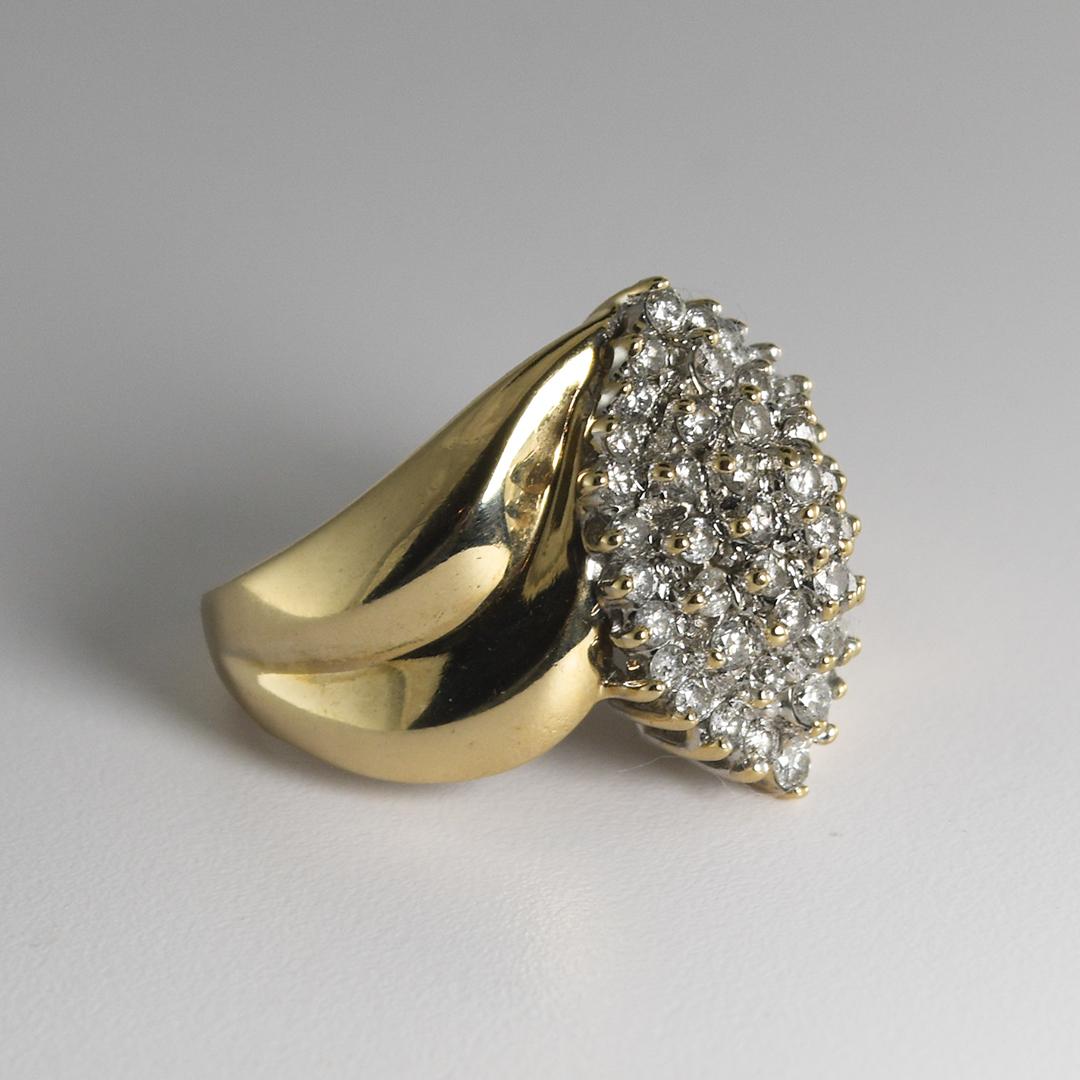 This cluster style 10 karat yellow and white gold ring weighs 5.80 grams.
It contains fifty-nine small round brilliant diamonds, with a total carat weight of 1.0 and are mounted in a prong setting.
The width measures 0.75 inch and is a size 7.
It