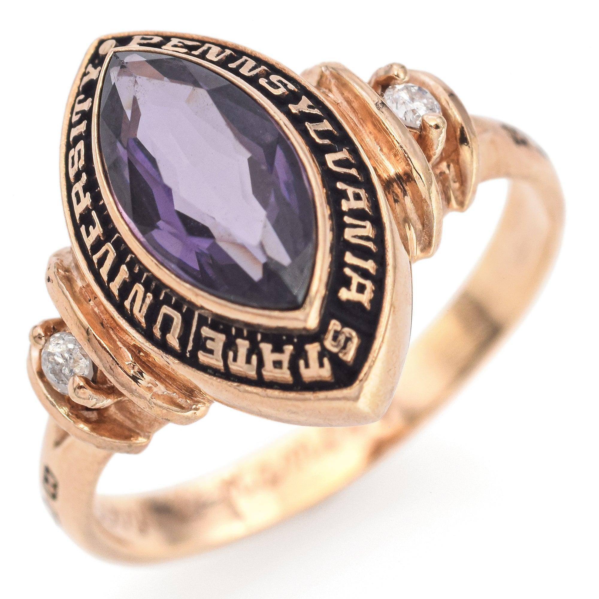 Crafted in warm 10K yellow gold, this Penn State University class ring features a marquise-cut lab amethyst weighing approximately 0.80 carats. The stone is framed by bold black enamel lettering reading Pennsylvania State University. Each shoulder