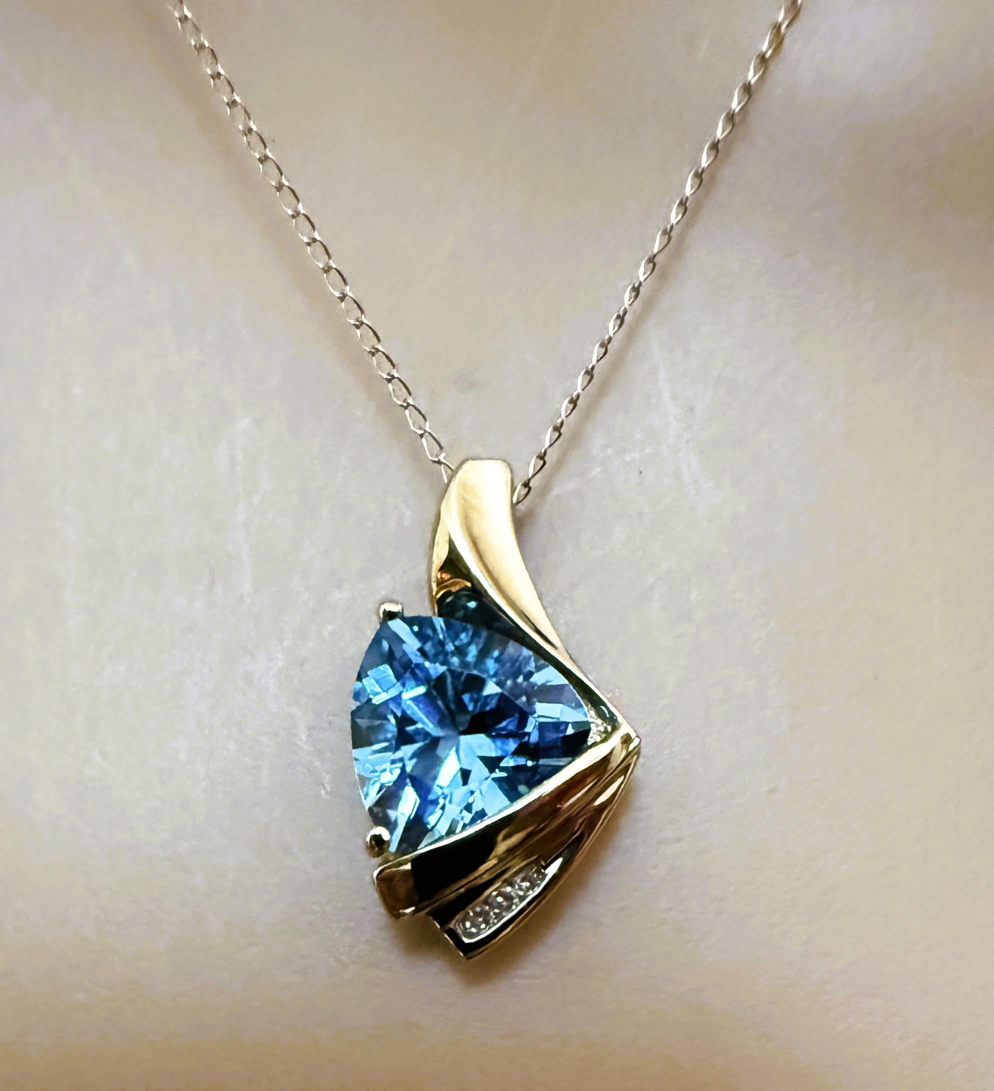 Das ist ein tolles Design!  Der Anhänger hat einen 10 mm großen Blautopas im Billionenschliff und ist mit 3 Diamanten im Brillantschliff verziert.  Die Diamanten sind 1,25 mm groß und haben insgesamt 0,03 Karat.  Sie sind alle in einer schönen