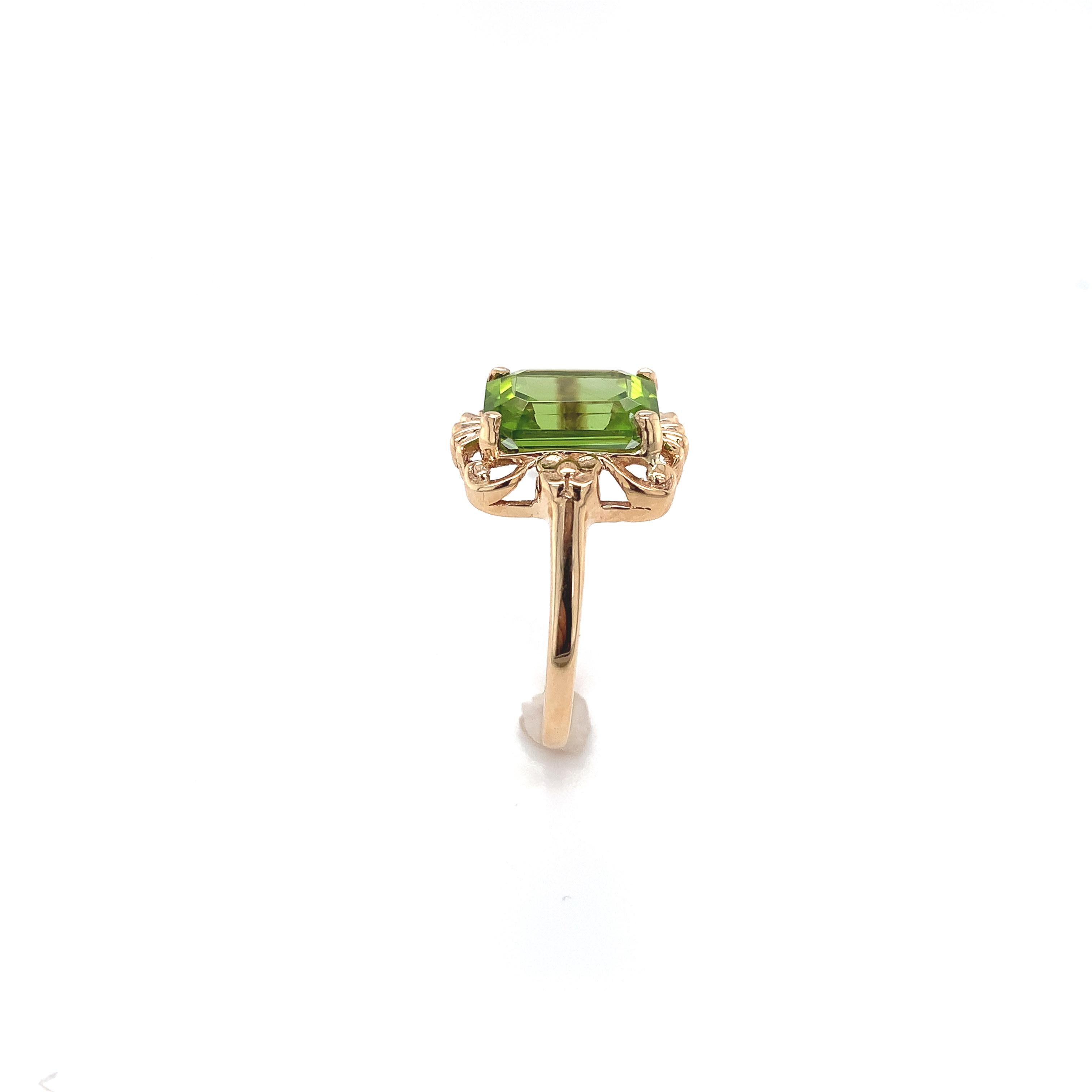 10K yellow gold ring featuring an emerald cut peridot weighing 3.73 carats. The vibrant lime green peridot measures about 10mm x 8mm. The ring fits a size 6.75 finger, weighs 1.79dwt. dates from the 1940-50's.