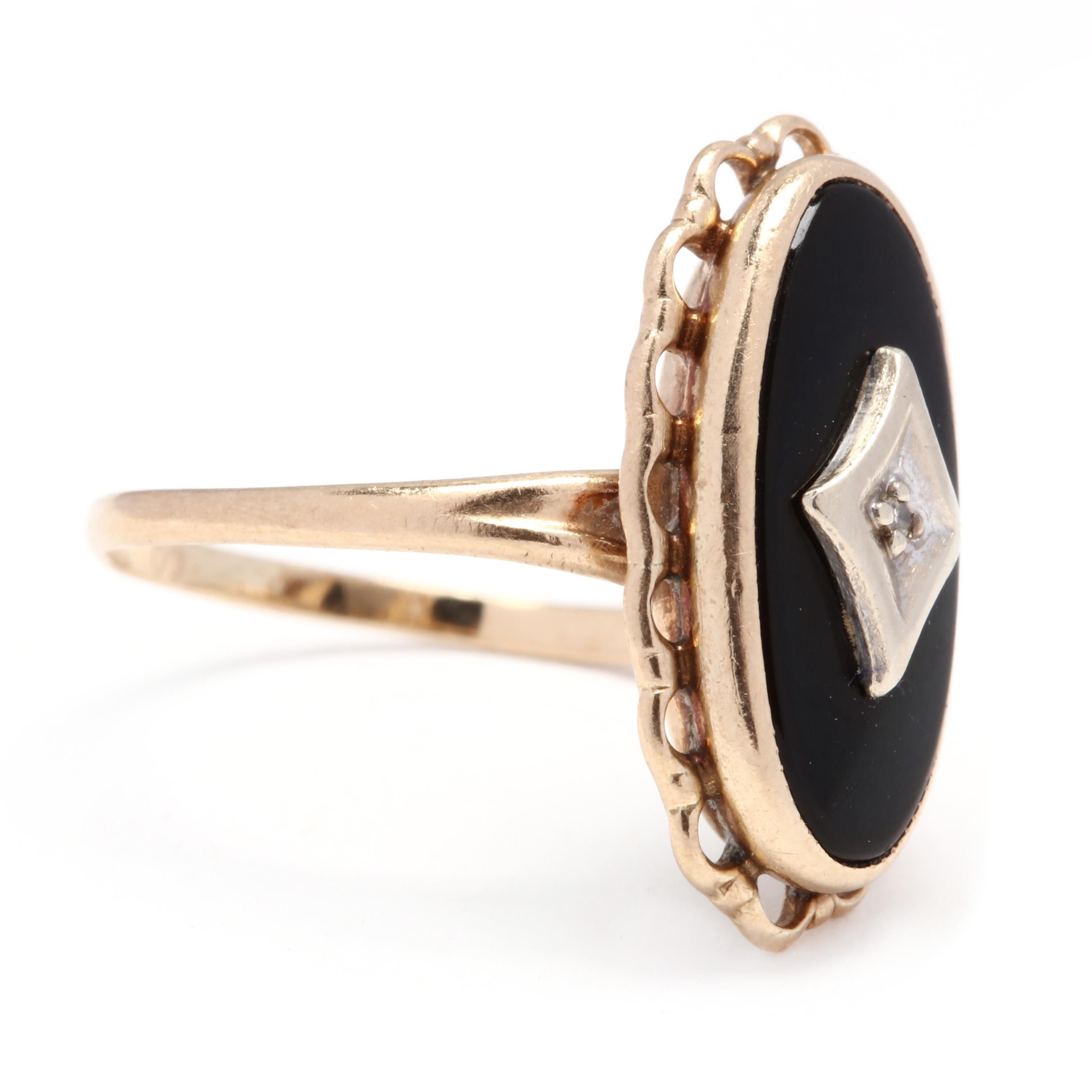 10k yellow gold black onyx and diamond oval ring. A classic 1940s ring with gold and a center diamond (0.0075 ct)  set in an onyx tablet. The ring is framed with a gold scalloped edge. This delicate style is dainty and still makes a