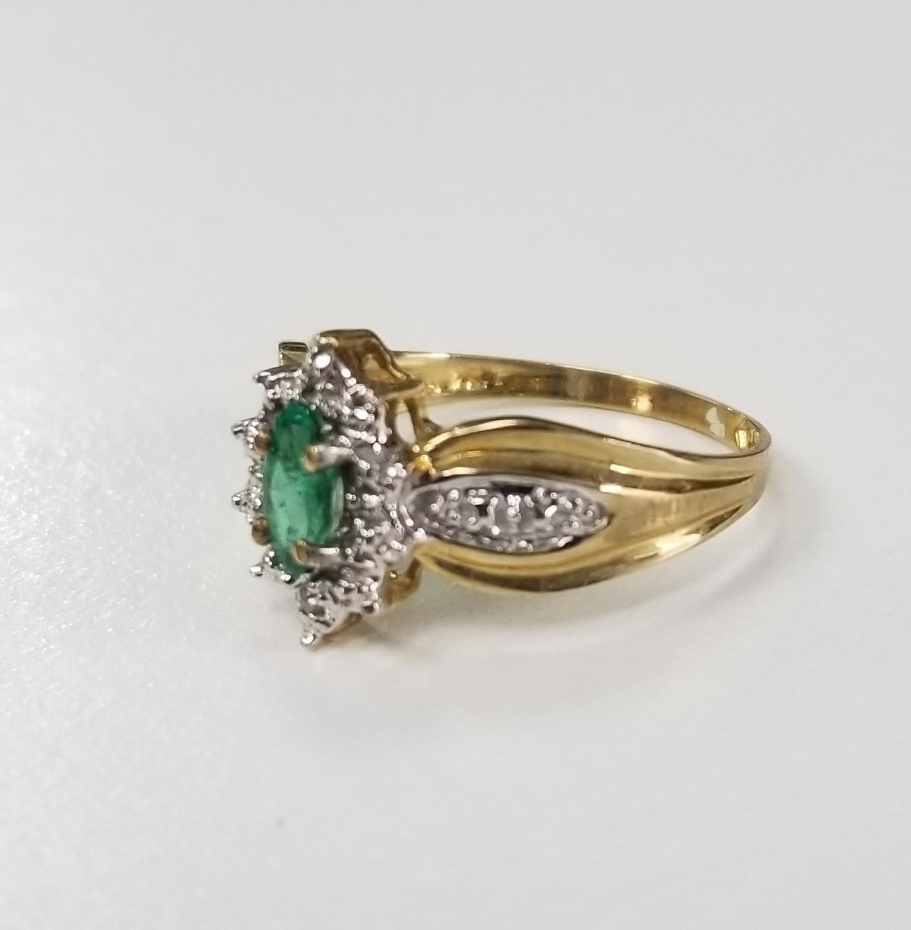 10k yellow gold Emerald and diamond ring, containing 1 marquise shape cut weighing .20pts. and 2 round full cut diamonds weighing .01pts.  This ring is a size 6 but we will size to fit for free.