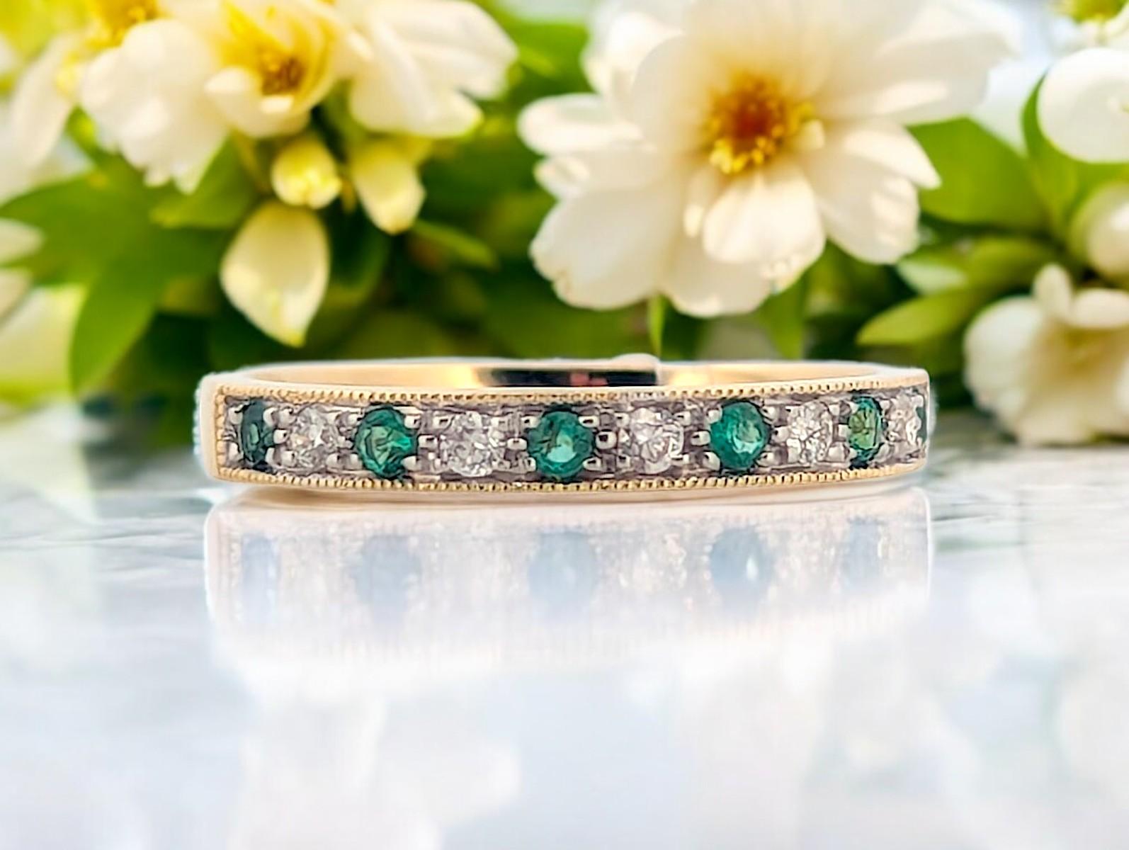 This exquisite 10K yellow gold band features 0.15 CTW of natural round emeralds set between 0.11 CTW of sparkling natural diamonds, creating a refined and elegant design. The vibrant green emeralds (May birthstone) add a pop of color, while the