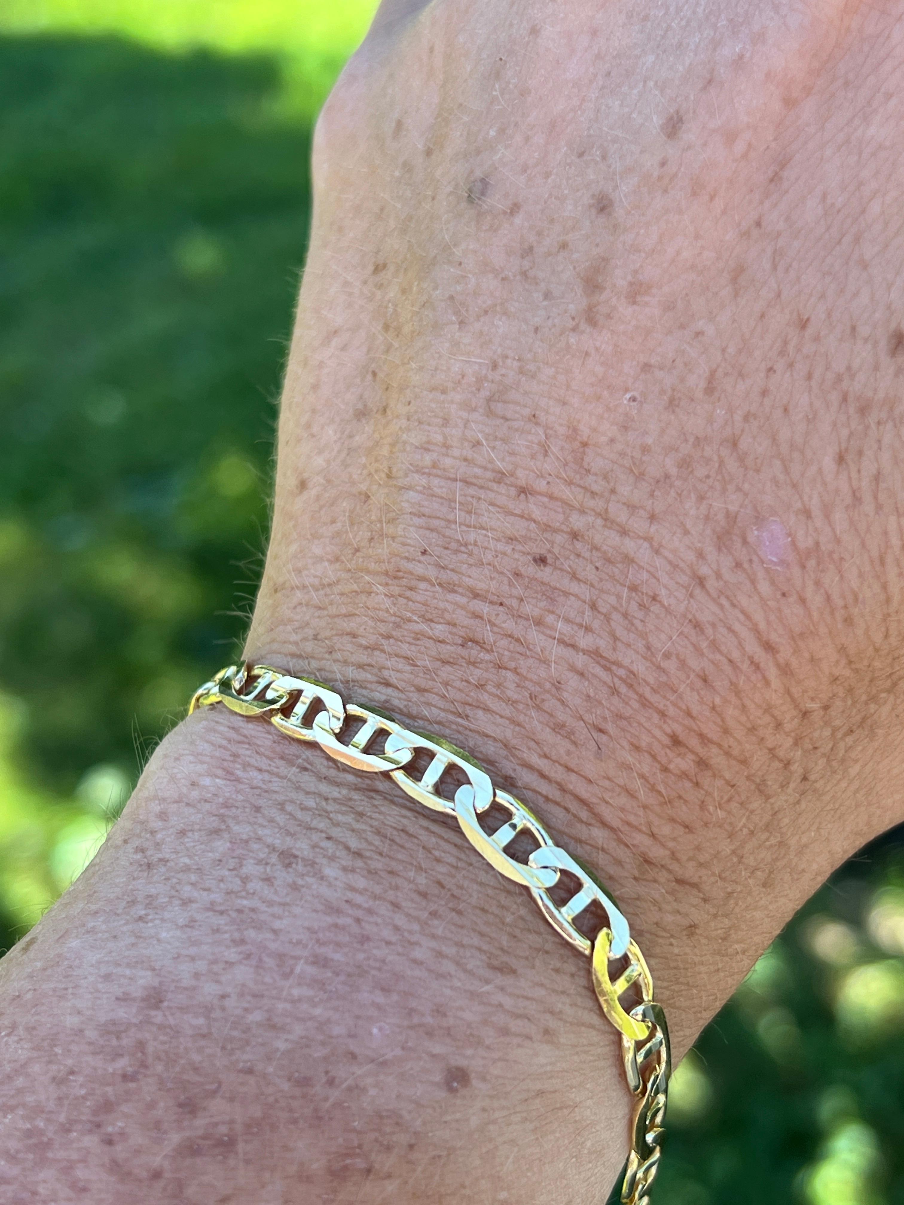 One contemporary 10 karat yellow gold flat link anchor/mariner chain bracelet complete with a lobster claw clasp. This bracelet is 0.22 inches wide and 9 inches long and is resizable however this is not a service we offer. 
