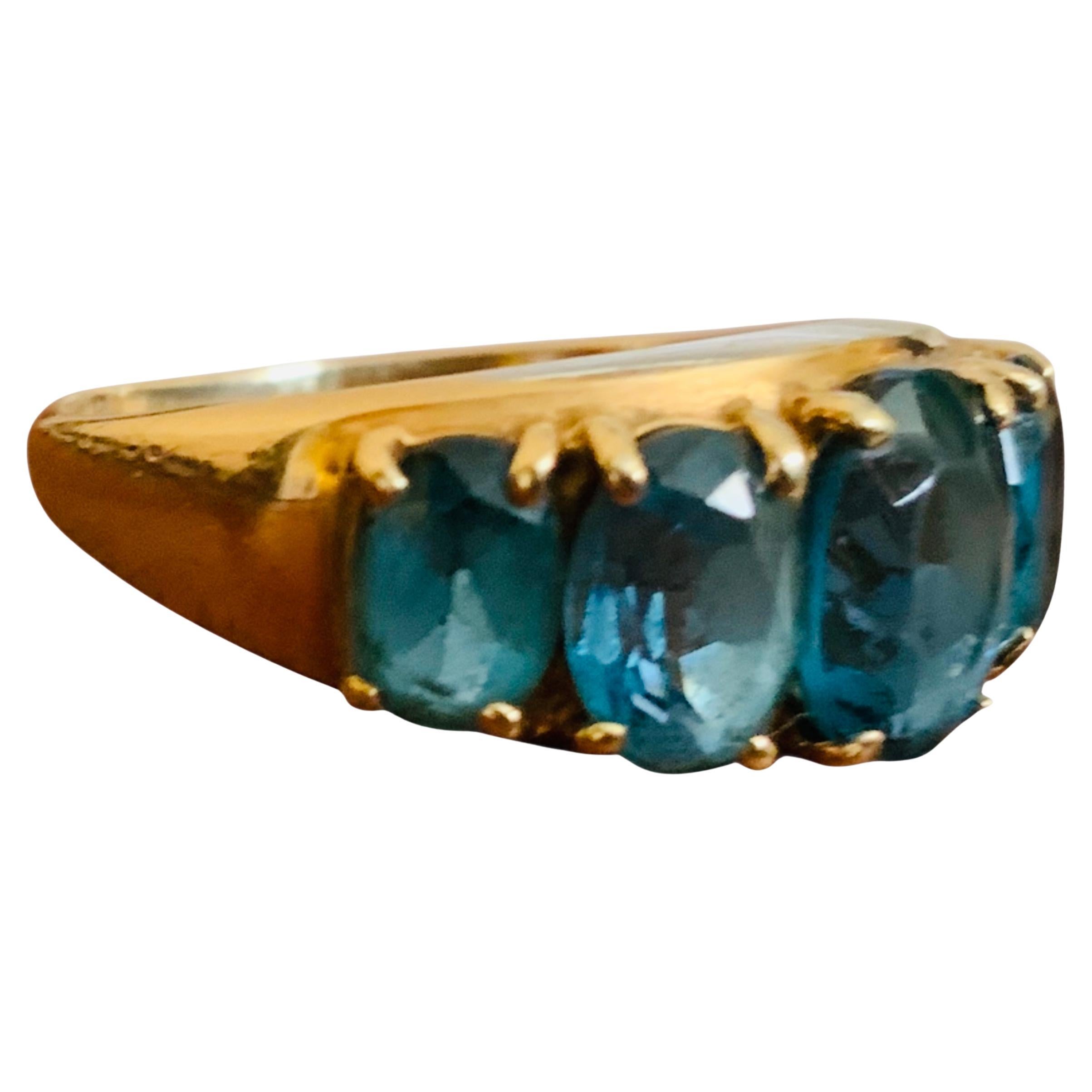 Questo è un anello di eternità in oro giallo 10K con topazio blu di Londra. Raffigura un anello a fascia in oro giallo ornato da cinque pietre di Topazio Blu di Londra di forma ovale con incastonatura a forchetta del peso di circa 3,50 carati La