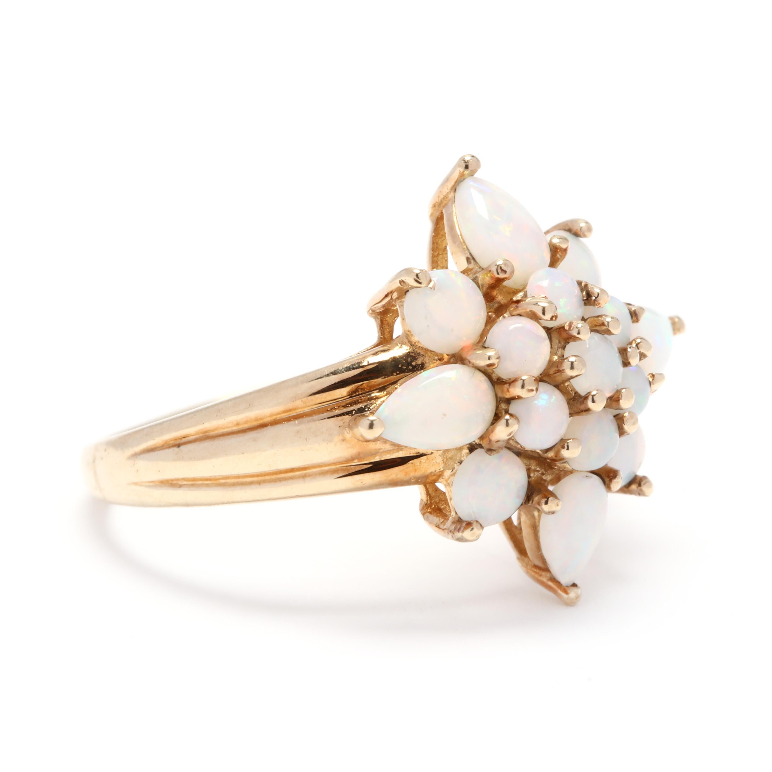 A 10 karat yellow gold and opal star statement ring. This ring features pointed star design made of a cluster of round and pear shape cabochon opals and with a tapered, ridged shank.

Stones:
- opal, 15 stones
- pear cabochon
- 5 x 3 mm
- round