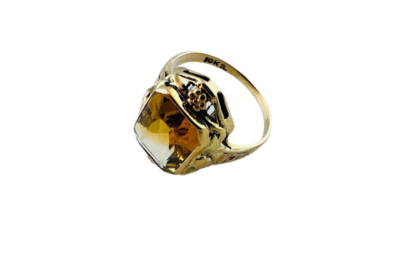 This beautiful yellow gold ring is set with a center faceted orange citrine stone. 

Filigree 10K yellow gold frame around stone is detailed with floral accents

Stampe 10K S

Shank is approx. 1.4mm

Front of ring measures approx. 17.1 x 11.9 x 5.1