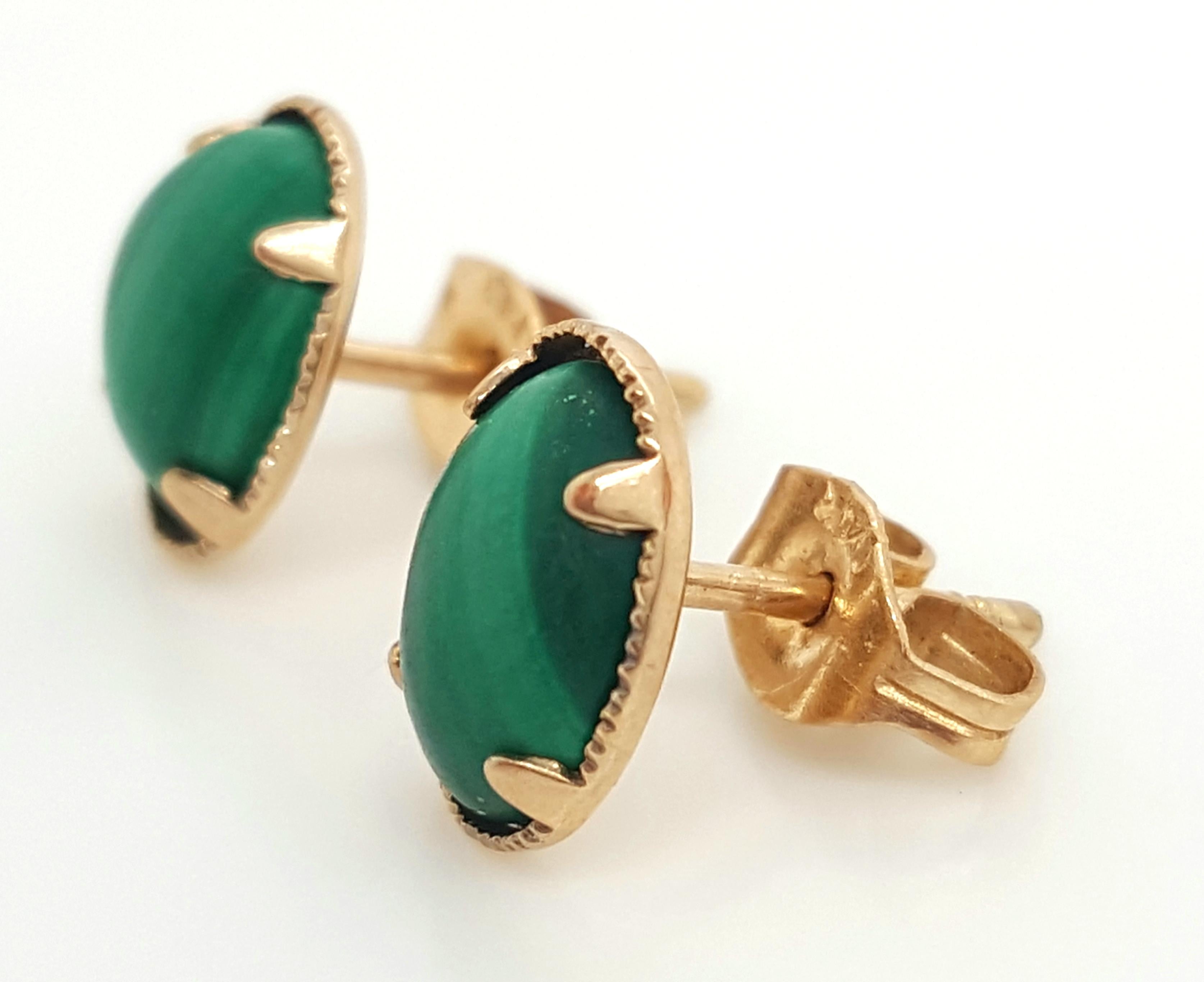 10 Karat Yellow Gold Oval Cabochon Malachite Stud Earrings.  The earrings feature a pair of oval shaped cabochon malachite. The malachite are each set into a 14 karat yellow gold four prong setting, completed by posts and friction backs.  Earrings