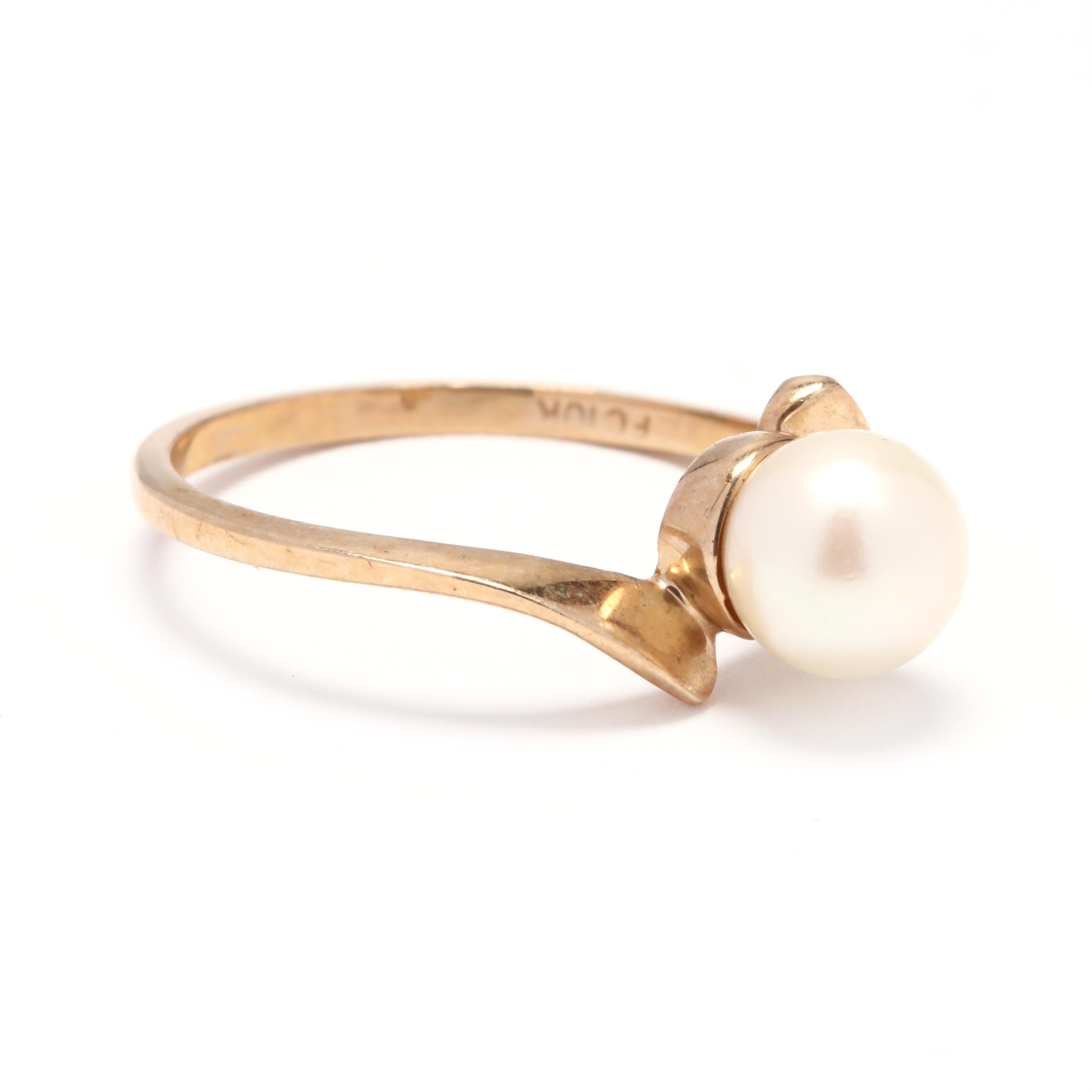 A 10 karat yellow gold and pearl bypass solitaire ring. This ring features a 6.8mm white pearl set in a thin, bypass mounting.

Stones:
- pearl
- round bead, 1 stone
- 6.8 mm

Ring Size 6.75

1.35 dwts.

* Please note that this is a vintage item and