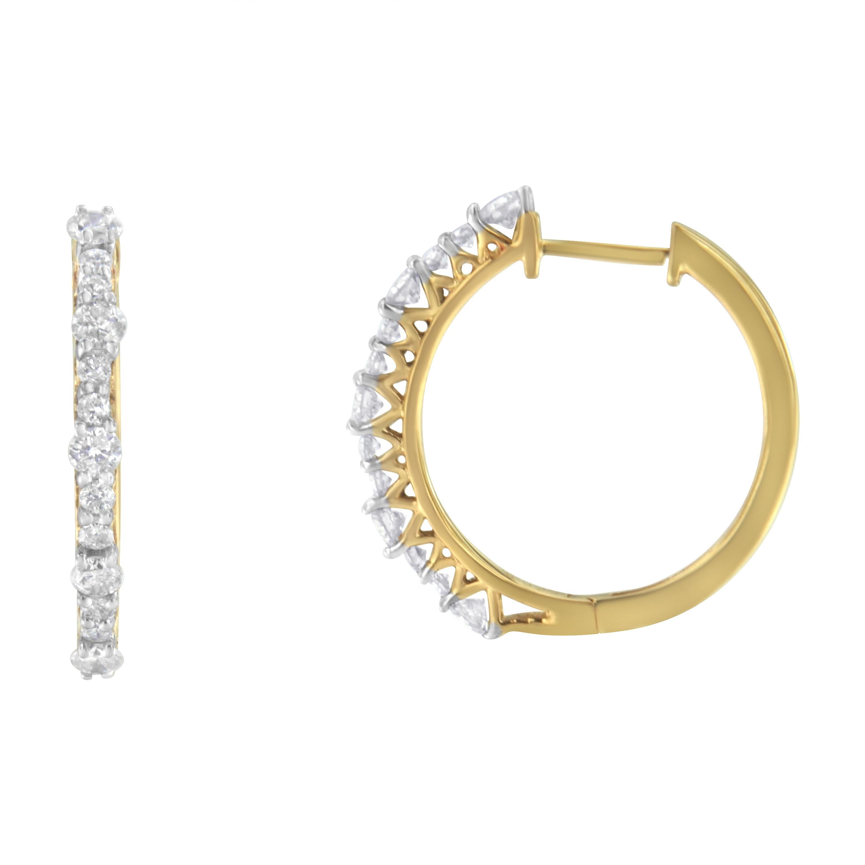 An elegant pair of diamond hoop earrings featuring diamonds of graduated size set into yellow gold plated sterling silver hoops. A classic design for a special occasion. They have a total diamond weight of 1 carat. The base metal is sterling silver