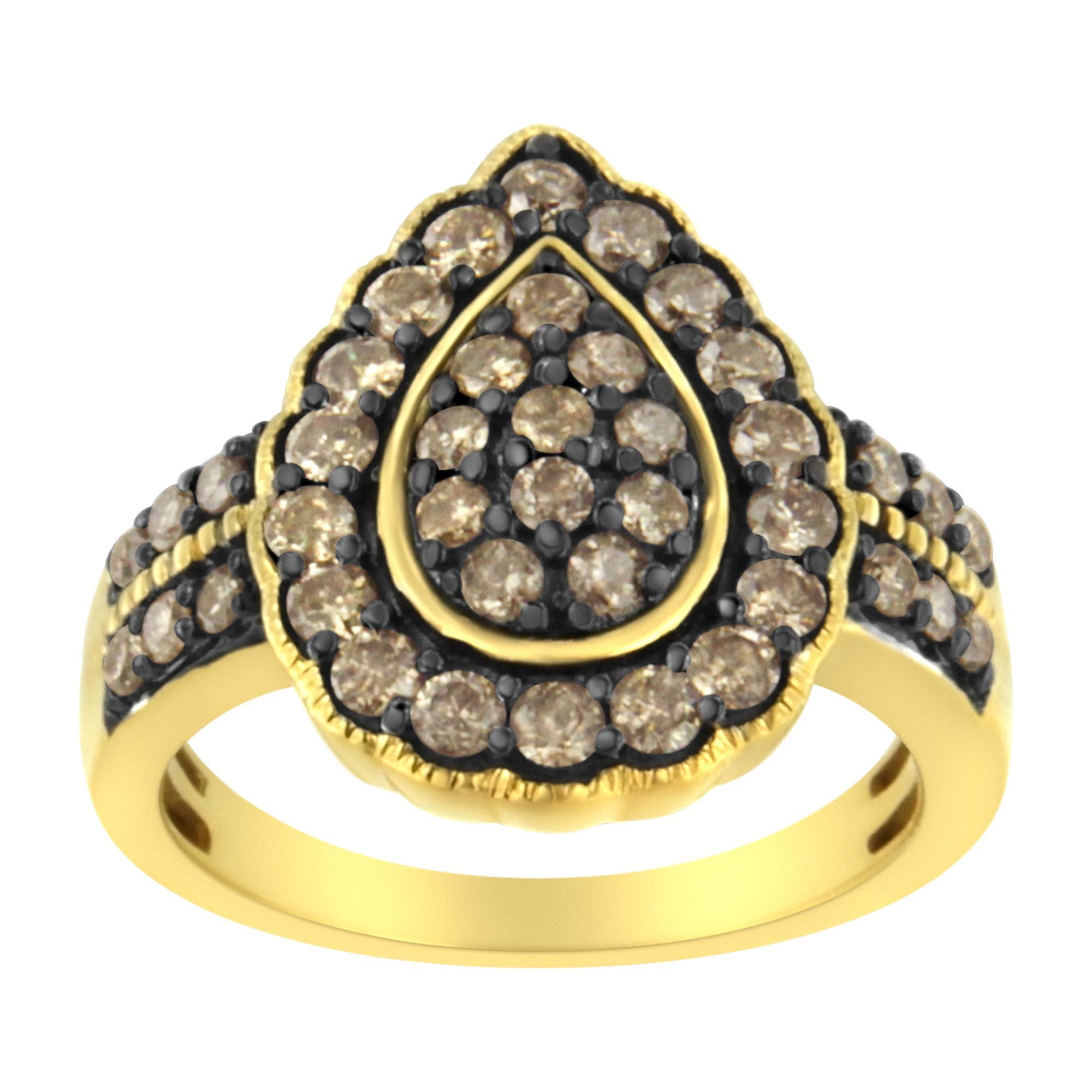 This unique design features 1 1/8ct TDW of diamonds. Sparkling round cut diamonds in a drop shaped cluster sit at the center of a diamond studded halo. A double row of round diamonds inlay the ring band and flank the sides of the central design.
