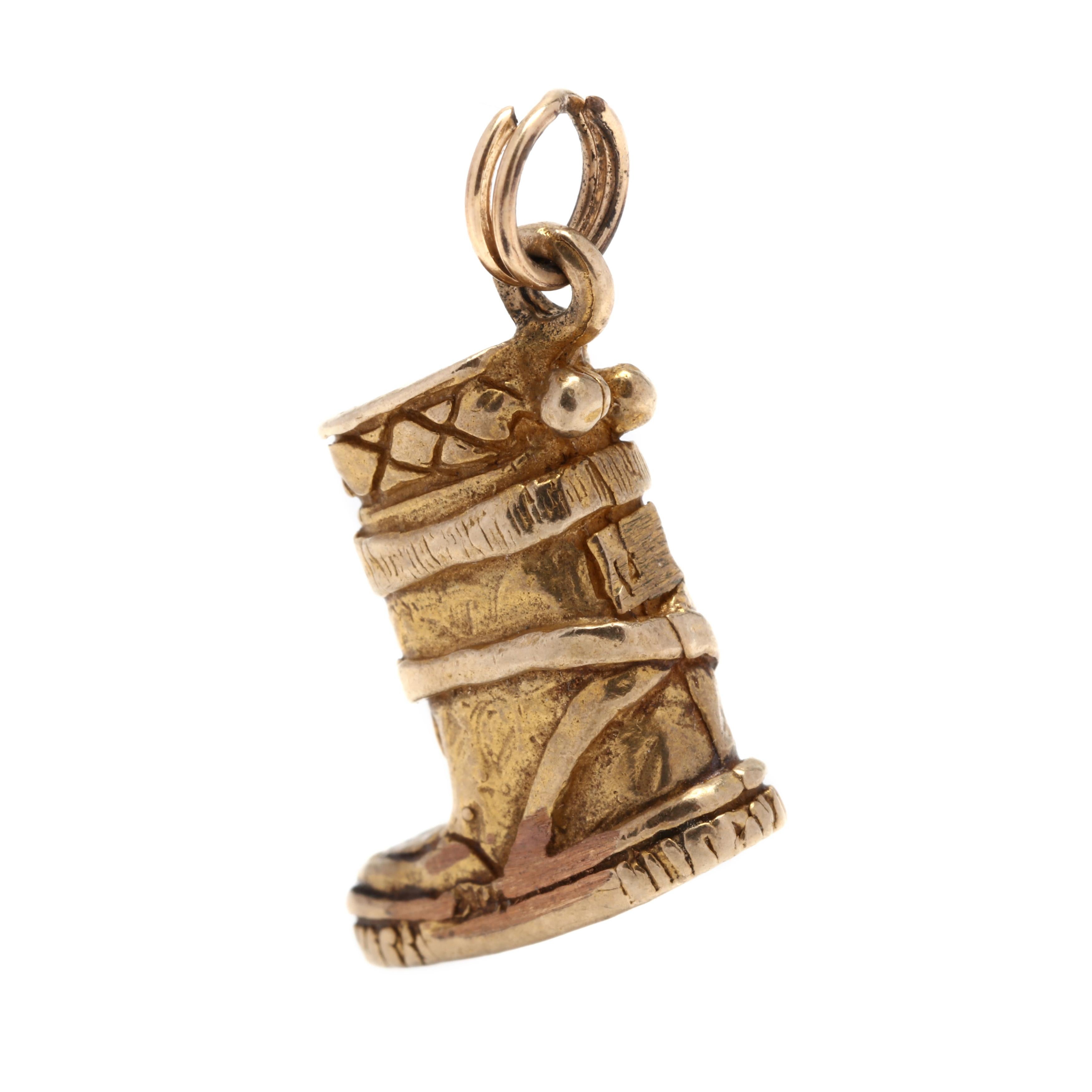 A 10 karat yellow gold snow boot charm. This charm features an Alaskan snow boot motif with engraved detailing and a round jump ring / bail.



Length: 3/4 in.



Width: 7/16 in.



Weight: 2 dwts.