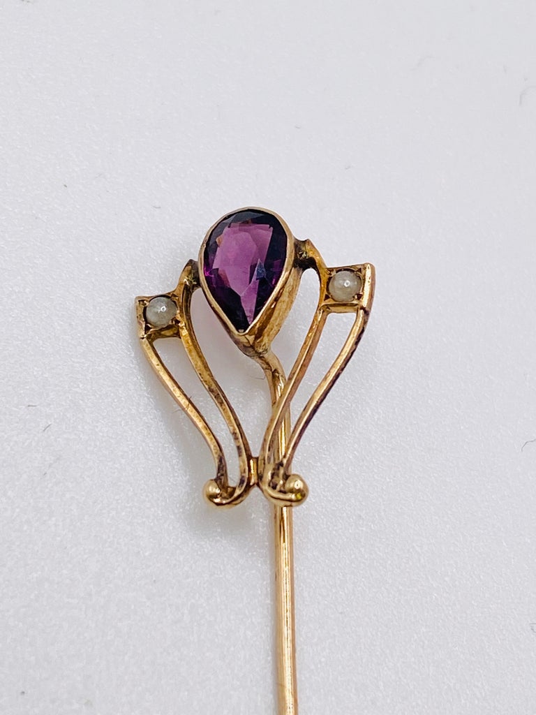 10K yellow gold Victorian stick pin with one approximate.5 carat pear shaped amethyst and 2= 1.5mm round pearls. 1.0Dwt/1.5 gm
