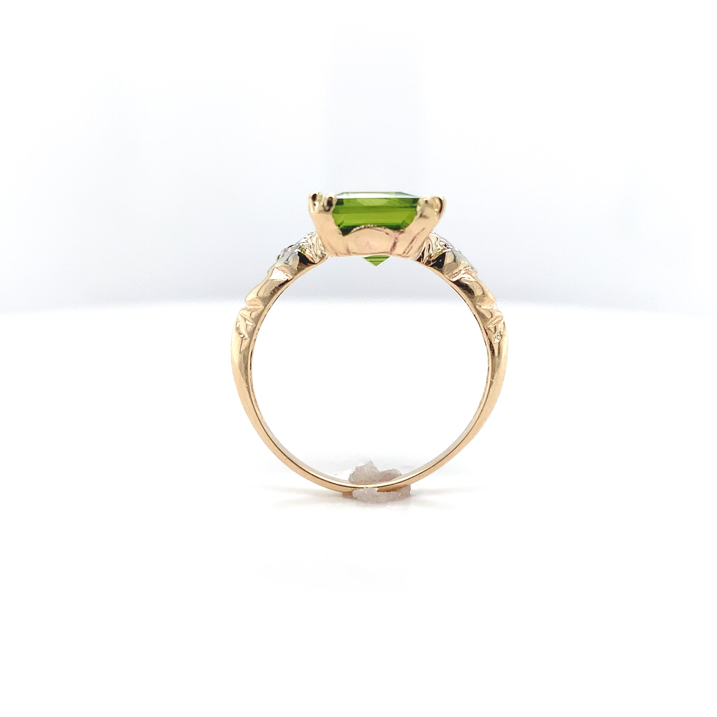 10K yellow gold ring featuring an emerald cut peridot weighing 3.48 carats. The vibrant lime green peridot measures about 10mm x 8mm. There are 2 tiny rose/polki cut diamond accents set in white gold. The ring fits a size 6.25 finger, weighs