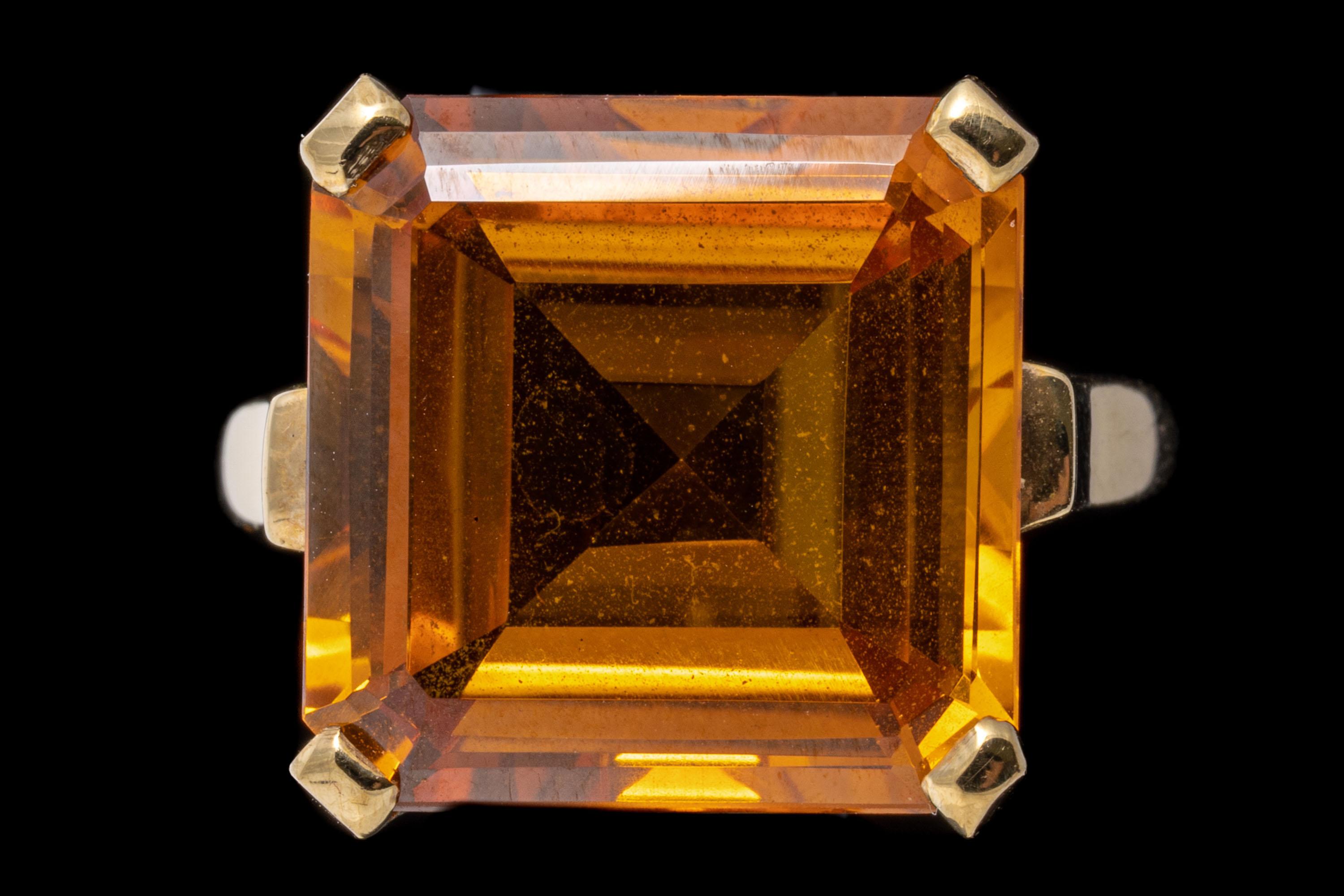 10k yellow gold ring. This simple vintage ring features a center square faceted, yellow orange lab grown sapphire, decorated with a scrolled gallery and airline styled shoulders.
Marks: 10k
Dimensions: 9/16