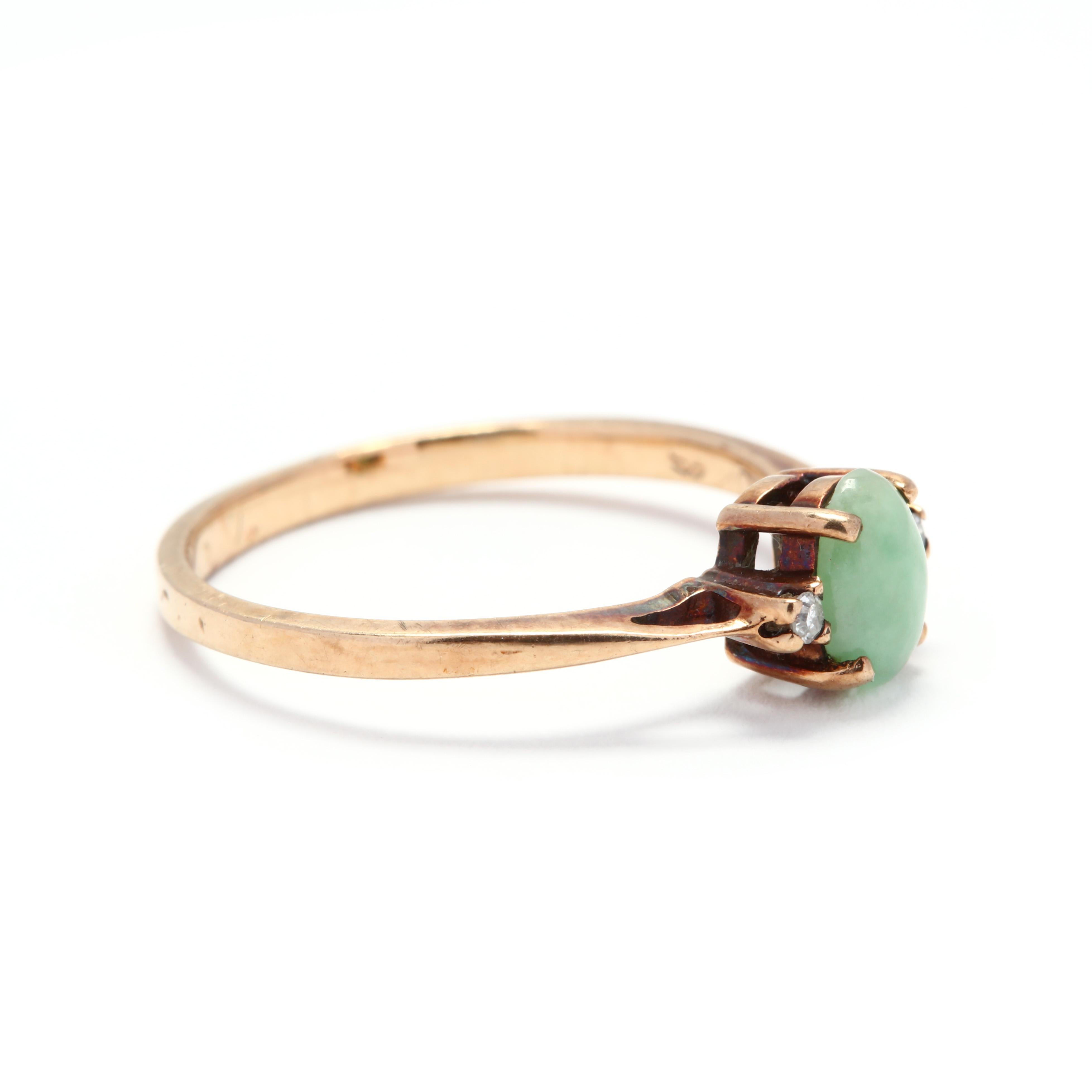 A 10 karat yellow gold, jade and diamond ring. Centered on a prong set, oval cabochon jade stone with a full cut round diamond on either side. A minimalist's dream!

Stones:
- jade, 1 stone
- oval cabochon
- 6.25 x 4 x 1.92 mm

- diamonds, 2