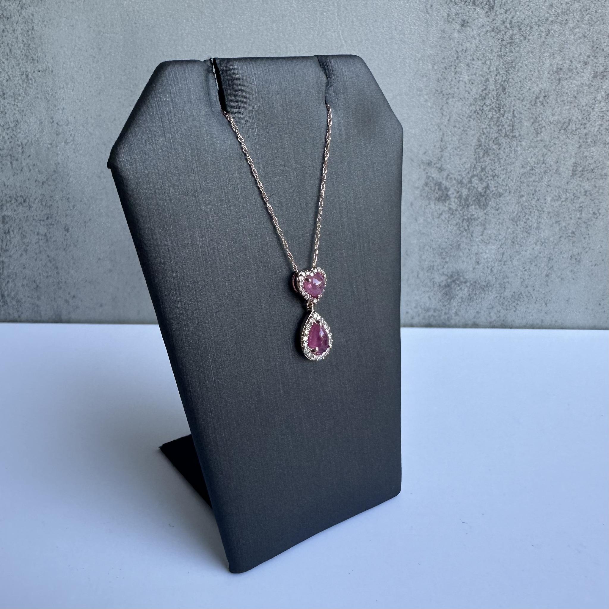 Elevate your jewelry collection with this elegant Ruby and Diamond Necklace in 10kt Rose Gold. Featuring two stunning pink cabochon cut rubies and 0.15 carats of GH VS natural round single cut diamonds, this necklace exudes sophistication and charm.