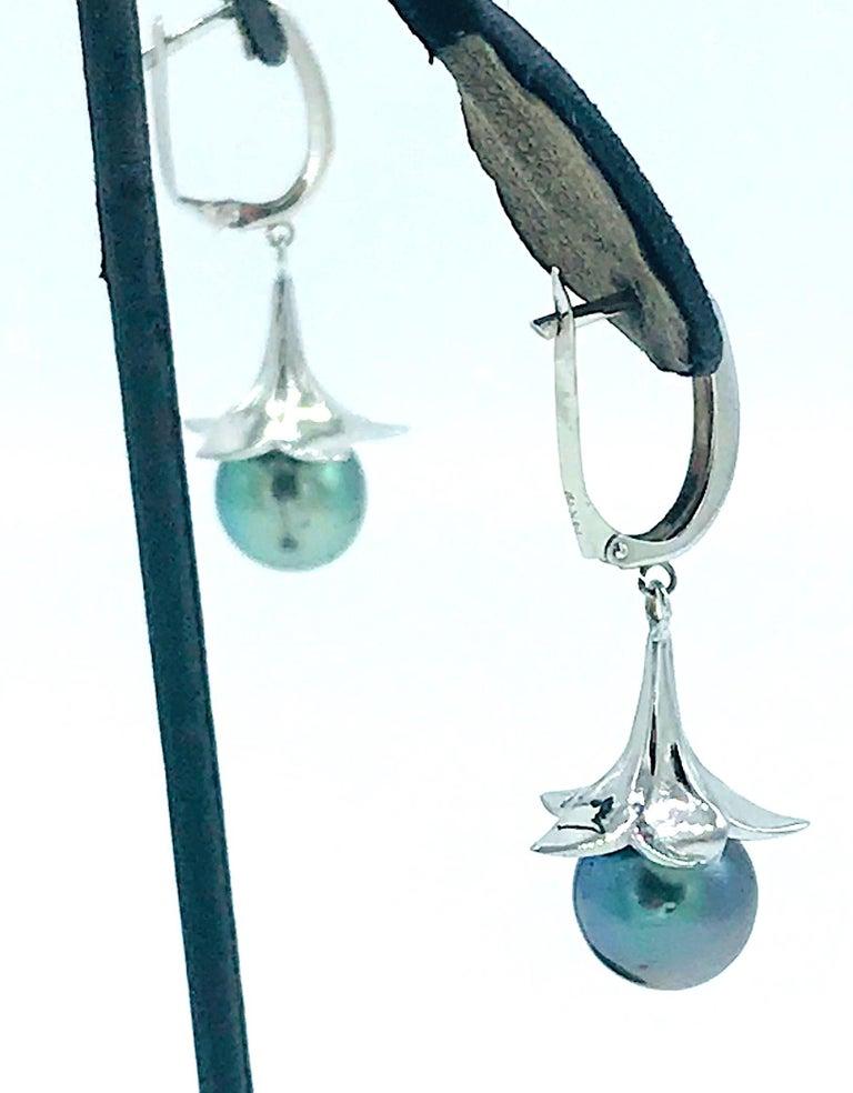  Tahitian Pearl Drop lever back Earrings are made in 14 karat White Gold. 
Stunning 10.10 mm Gray Tahitian pearls are featured as they are dropping from a flower-like petal.
The 2.65 mm wide Lever back earring settings are quality and durable to