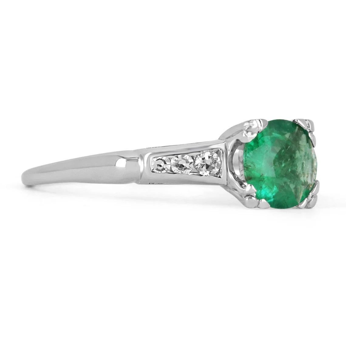 Featured here is this dainty emerald and diamond engagement/anniversary ring. The center stone holds almost a full carat of pure natural beauty. The stone displays a lovely shine and green color, as well as very good eye clarity. Accented on both