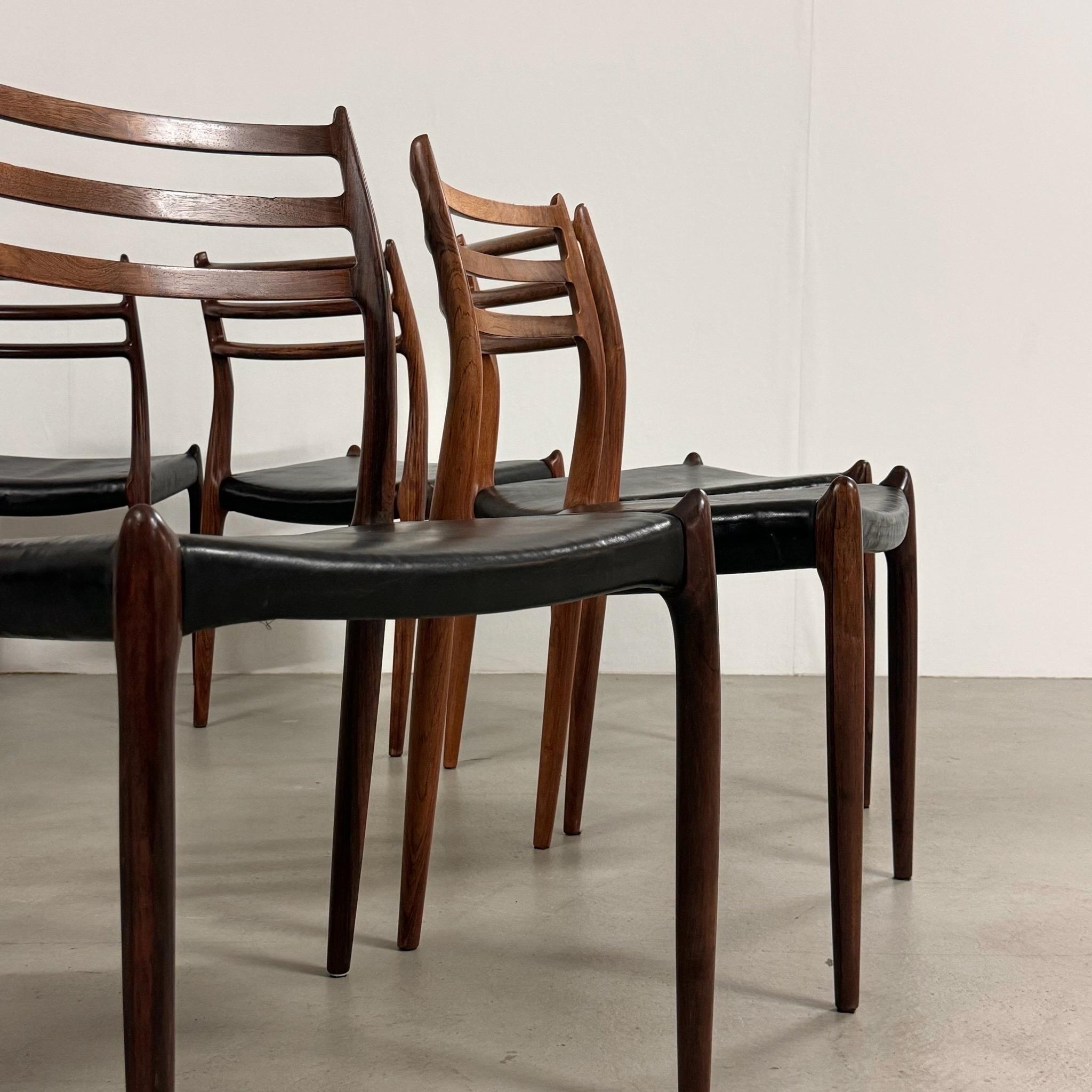 Set of 10 dining chairs Model 78, designed by Niels Otto Moller, manufactured by J.L. Mollers in the 1950s in Denmark. The chairs feature a solid rosewood frame with an original upholstery in black leather. Good vintage condition, without any