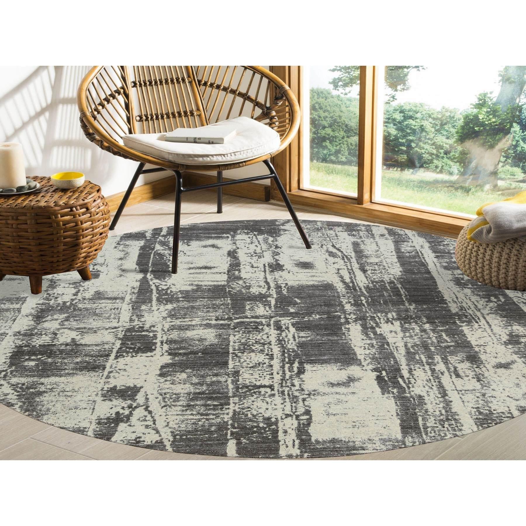 Se trata de una auténtica alfombra redonda oriental, única en su especie, de color negro carbón, tono sobre tono, diseño moderno, tejido a mano jacquard, lana y seda vegetal. Ha sido tejida durante meses y meses con técnicas artesanales de tejido