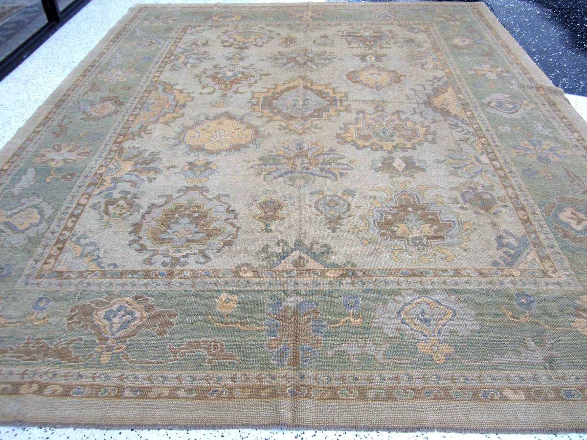 Eleva il tuo spazio con il nostro tappeto turco Oushak 10'x14' dal design grigio tenue e Sage, interamente annodato a mano e realizzato in Pakistan. Caratterizzato da un fantastico design di transizione, questo tappeto aggiunge stile e comfort di