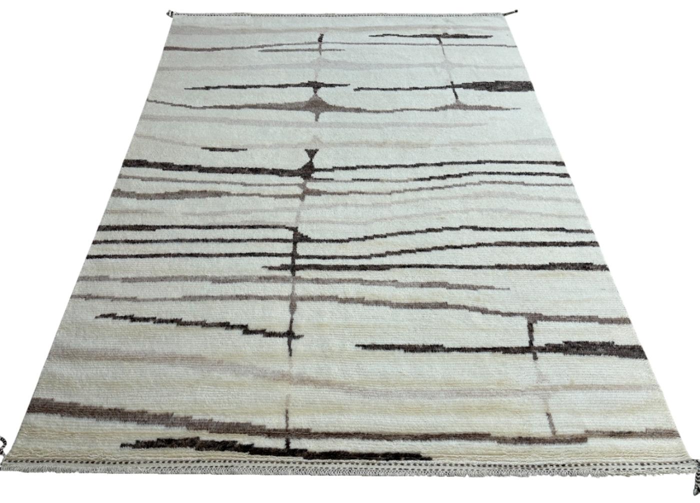Eleva tu espacio vital con el exquisito encanto de esta nueva y moderna alfombra de diseño bereber marroquí Beni Ourain anudada a mano, elaborada con precisión y cuidado a partir de 100% lana. Combinando el encanto del estilo marroquí con la
