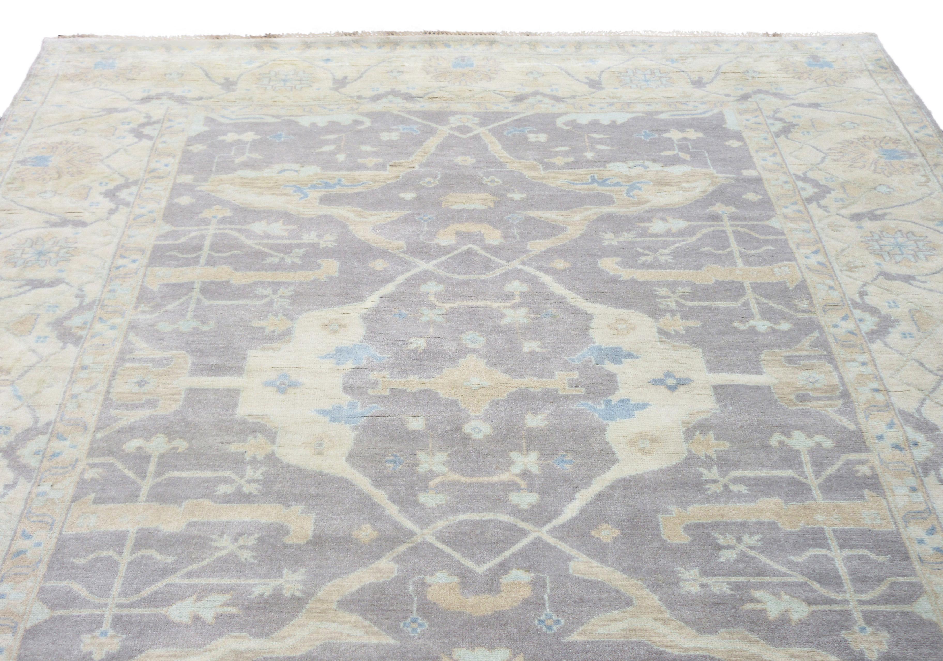 Handgeknüpft, Flor aus Wolle auf einer Baumwollgrundlage.

Abmessungen: 10' x 14' 

Feldfarbe: Grau

Farbe der Umrandung: Beige 

Akzentfarben: Braun, Blau.
