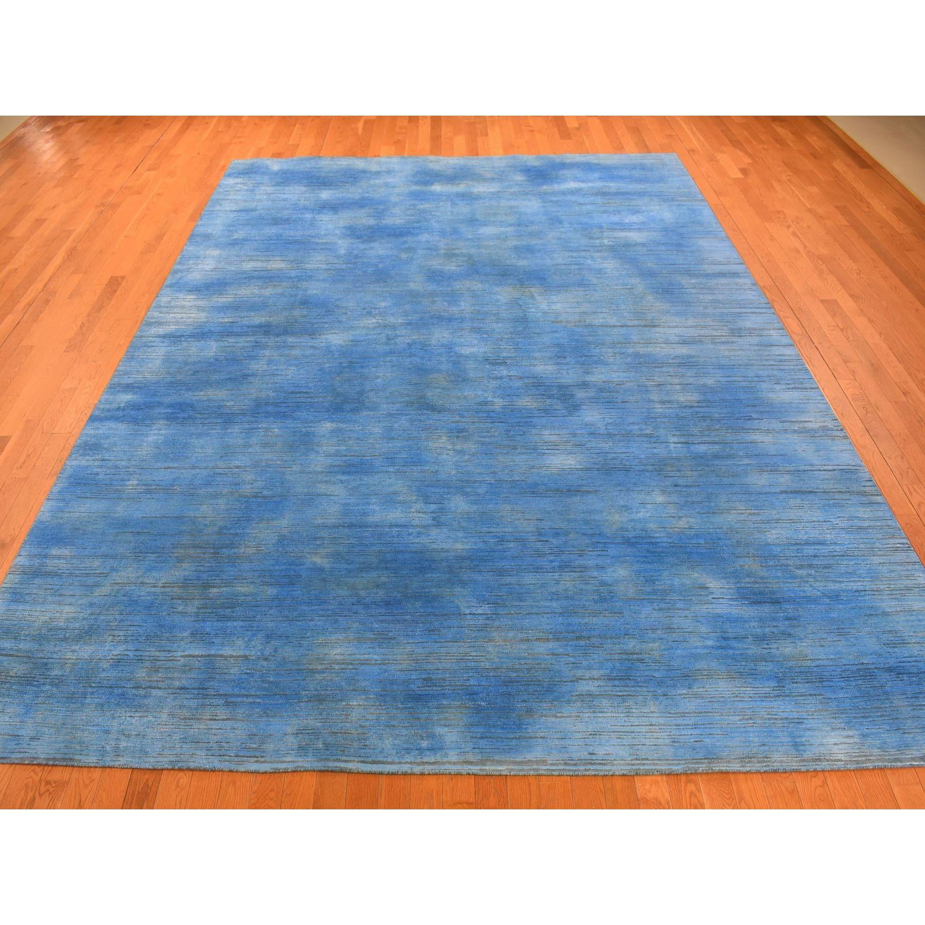 Si tratta di un autentico esemplare unico di tappeto orientale blu azzurro, in lana testurizzata annodata a mano e sovratinteggiata con un design contemporaneo di tipo 