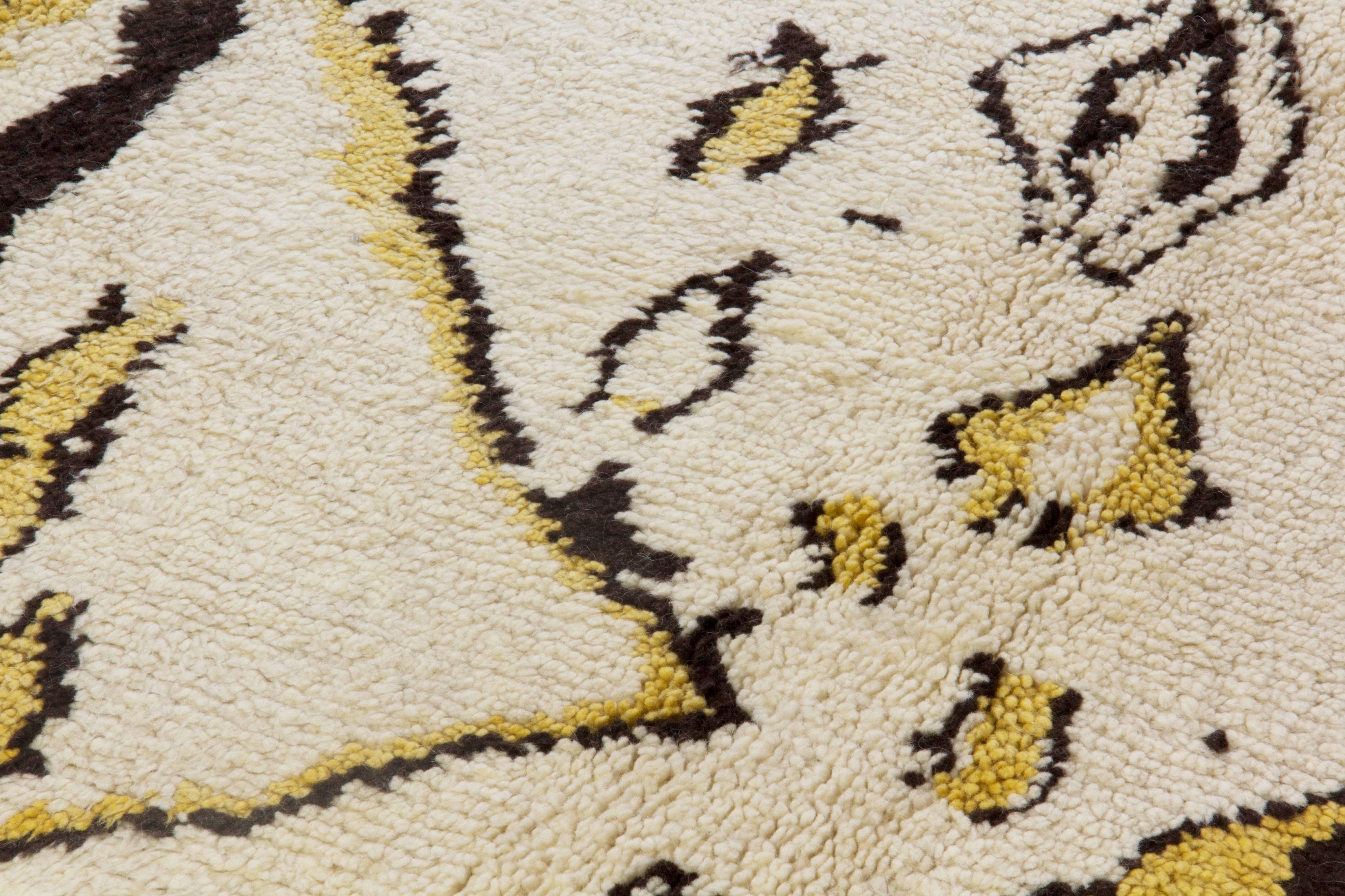 Tapis contemporain noué à la main en laine de mouton naturelle non teintée ivoire et marron foncé avec des accents jaune moutarde. Le design s'inspire des tapis marocains d'époque. 
Taille : 10 x 14.3 ft 
Le tapis est disponible tel quel ou, sur