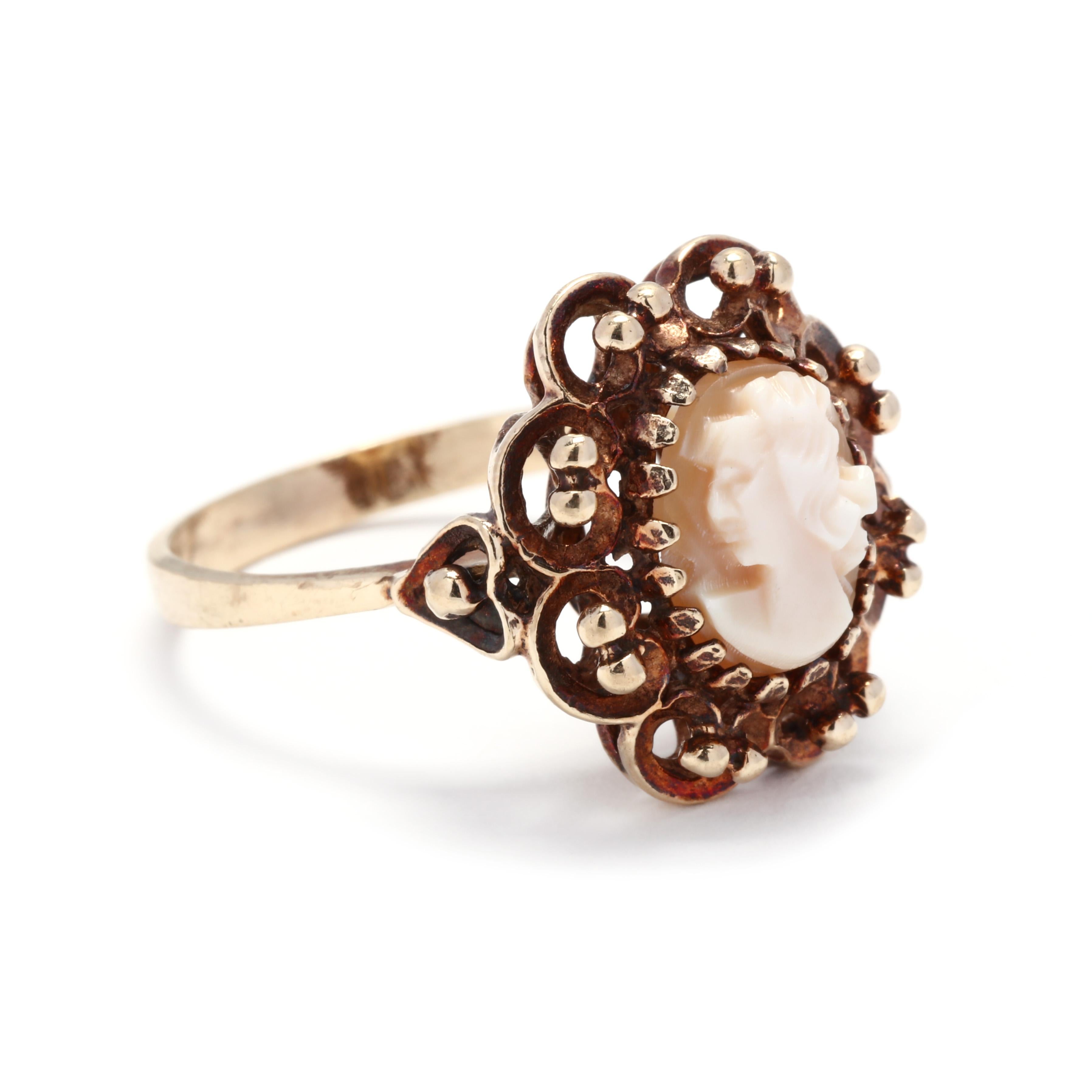 A vintage 10 karat yellow gold came ring. This ring features a carved shell cameo depicting a female profile surrounded be a beaded scalloped halo and a tapered band.



Ring Size 6.25 



Length: 5/8 in.



Weight: 2.10 dwts.