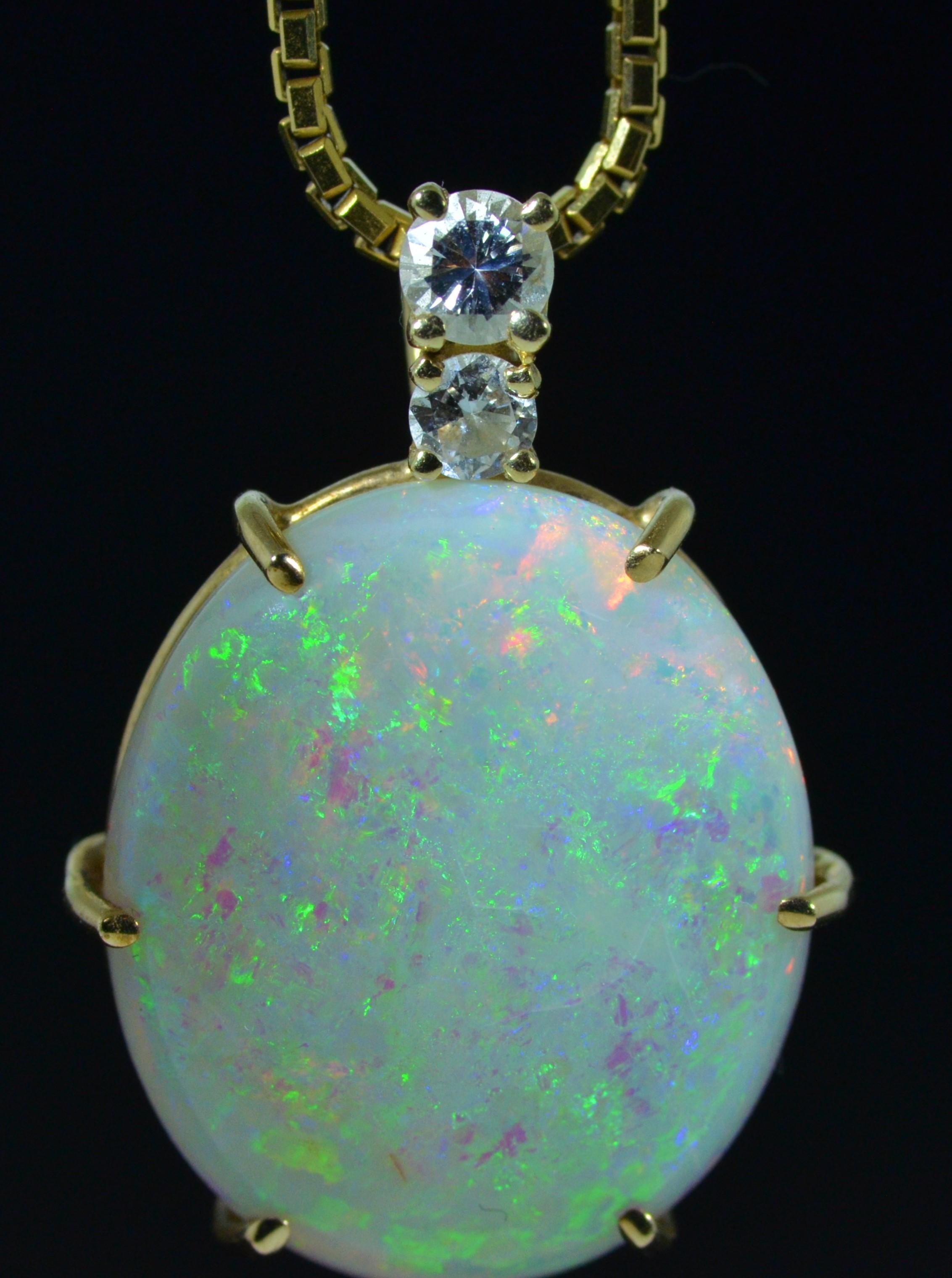 Outstanding pendant six (6) prong set with Impressive 11 Carat Fine Australian Opal.  Above the Oval shaped cabochon are two Round brilliant cut Diamonds. This opal is a true showpiece and absolutely incredible in nature!  Photographs do not do it