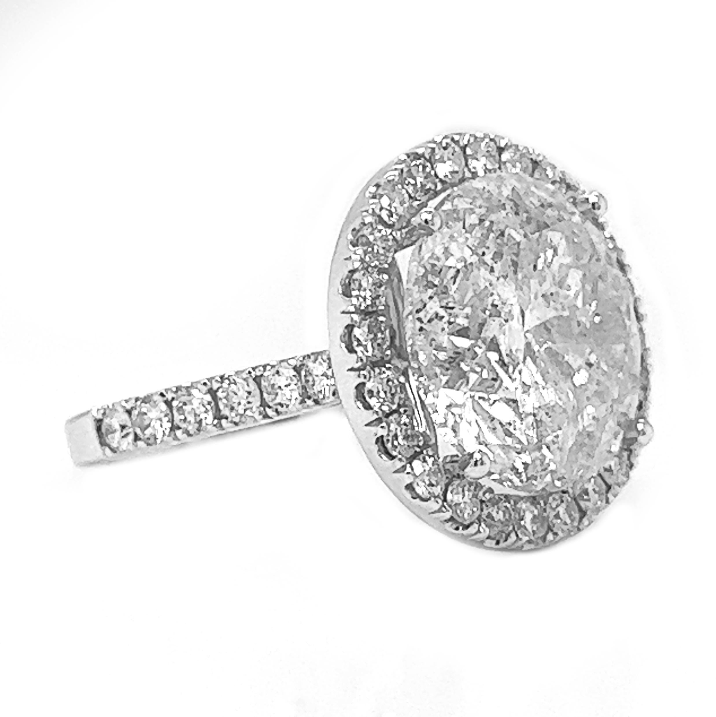 What makes this piece unique and special is its extraordinary 11-carat natural mined round diamond, which takes center stage in a captivating halo setting. This diamond is a true marvel of nature, exhibiting exceptional brilliance and sparkle. Its
