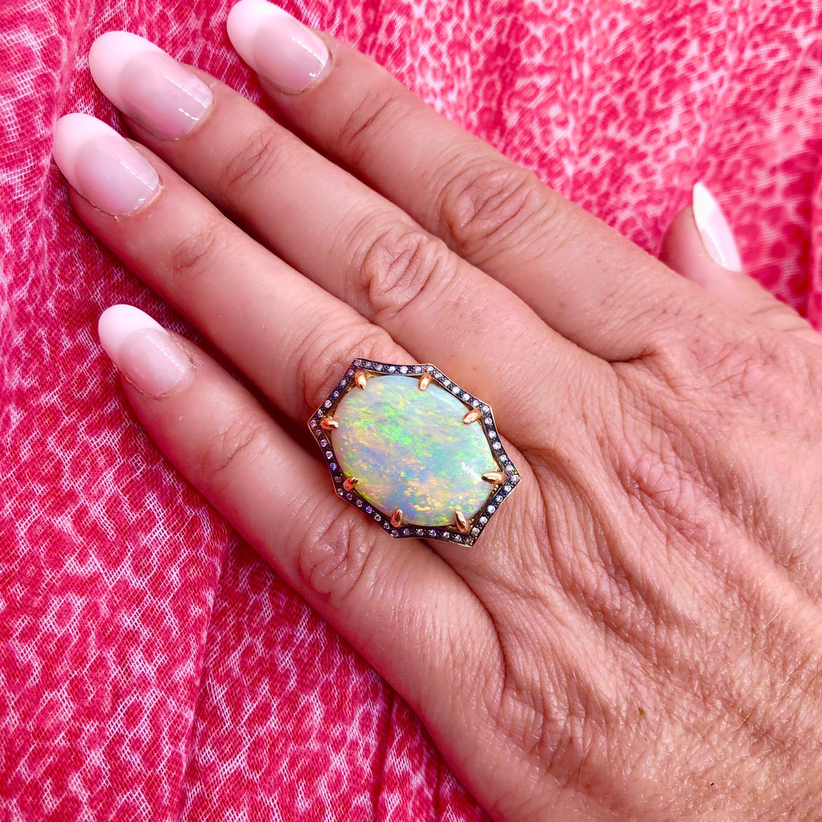 Exceptional Custom 11.00 Carat Australian Opal Set in 18Kt Rose Gold with a Halo of 48 Round Cut Diamonds. Opal has incredible play of color and beautiful vibrancy. The ring is a size 7.25 and weighs 14.4 grams. The perfect statement piece!