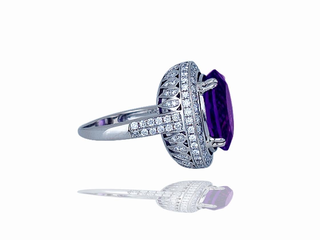 This stunning amethyst and diamond ring contains the following.  One grape colored amethyst that measures 16 x 12 x 10 mm.  The center amethyst is cut to perfection and has a stunning appearance when seen in person.  The center stone is surrounded