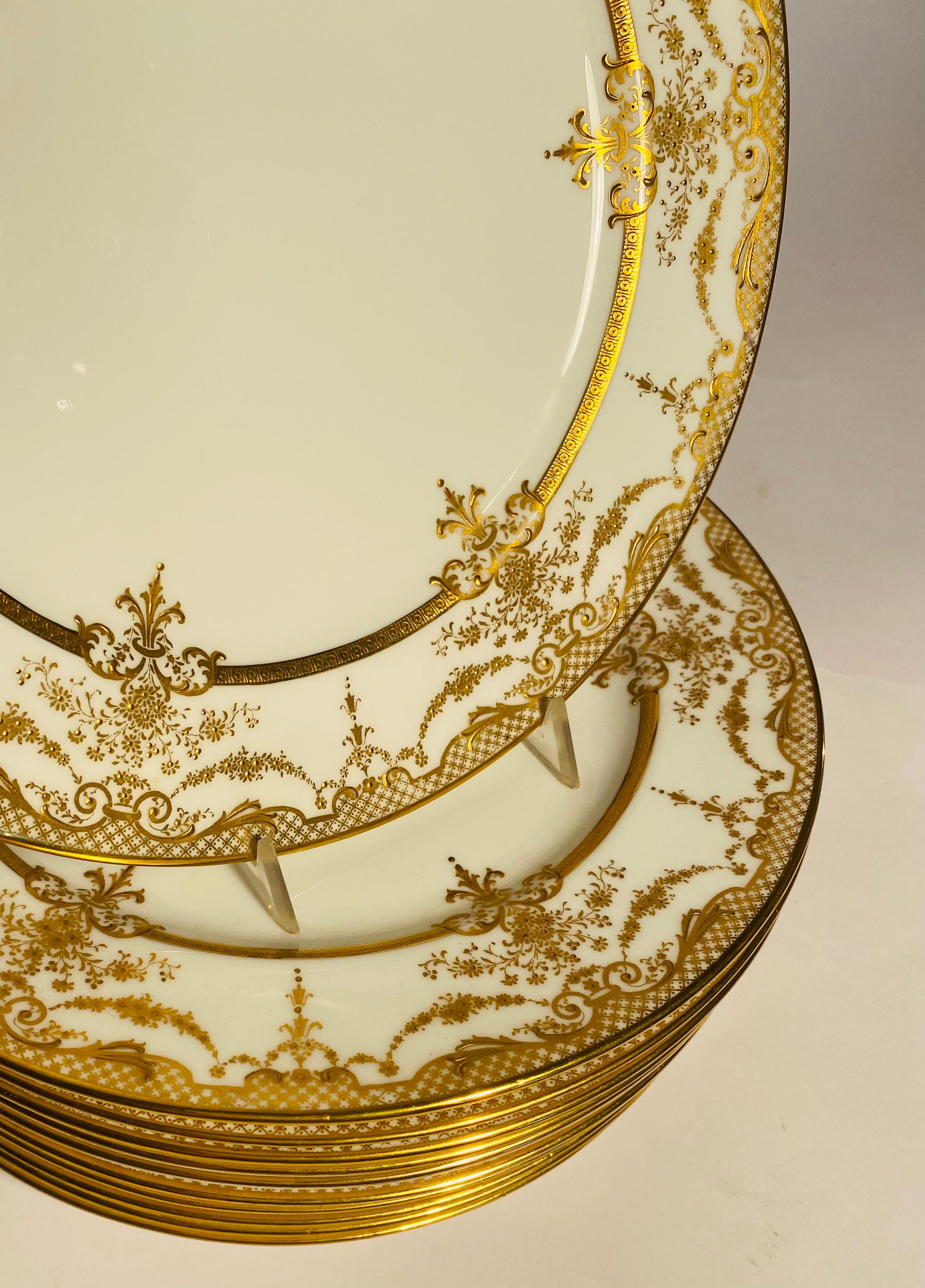 Elegante juego de platos de cena producidos por la conocida firma inglesa Royal Doulton para el fino minorista de la Edad Dorada Shreve & Co San Francisco. 
El intrincado diseño dorado en relieve de sus cuellos y la nítida porcelana blanca