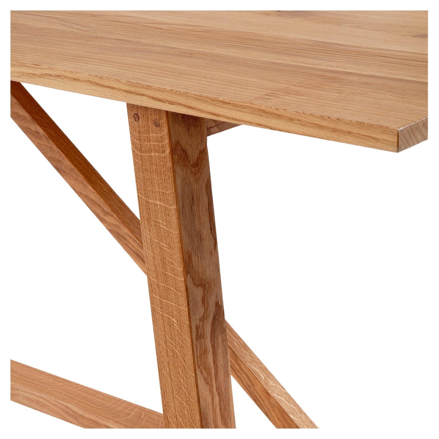 Inspired by the typical refectory table used in medieval convents characterized by a long, narrow, and thick top shelf, this austere table features a rectangular top supported by four cylindrical legs with multiple structural components enhancing