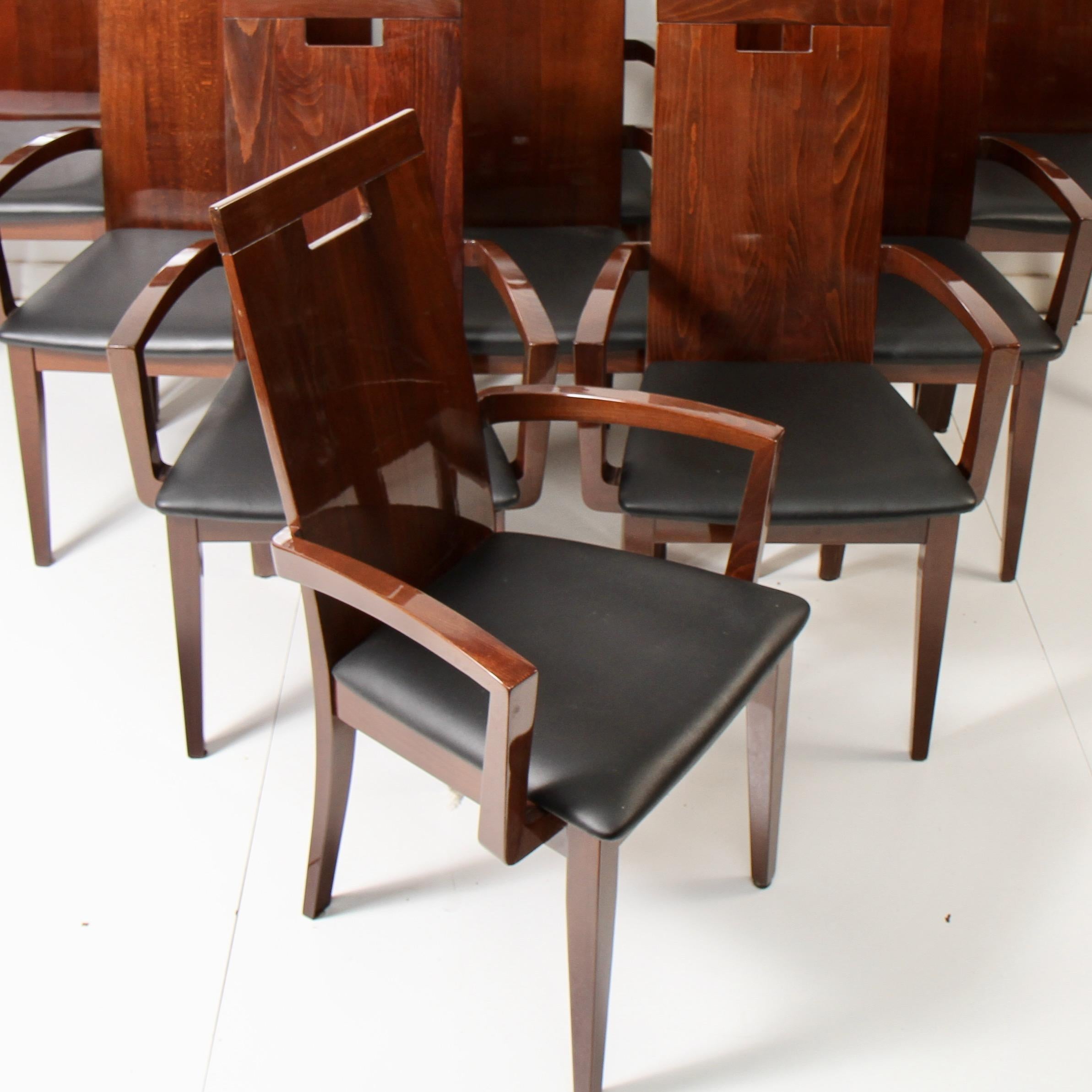 Recent 21st century dining set featuring 7 armchairs and 4 side chairs. Made of solid walnut with leather seats by Italian modern furniture maker Excelsior Designs. Blemishes in photos are either smudges or light reflection. Chairs in good condition