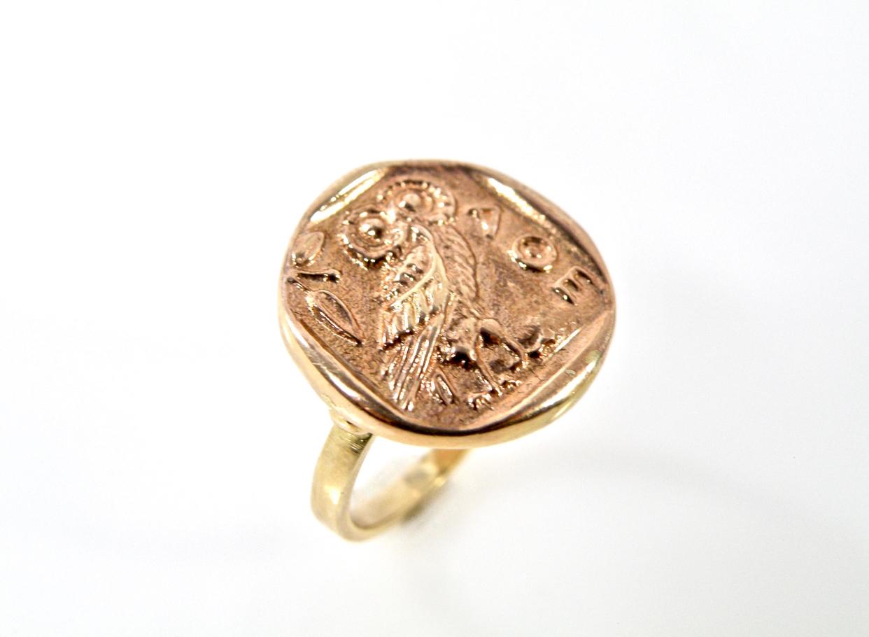 11 karat hand cast polished gold Owl  of Athena ring is a reproduction of an ancient Greek coin set in high relief, first minted over 2,000 years ago. Used as a symbol of knowledge and wisdom, the inscription AOE; is an abbreviation of AOHAION,