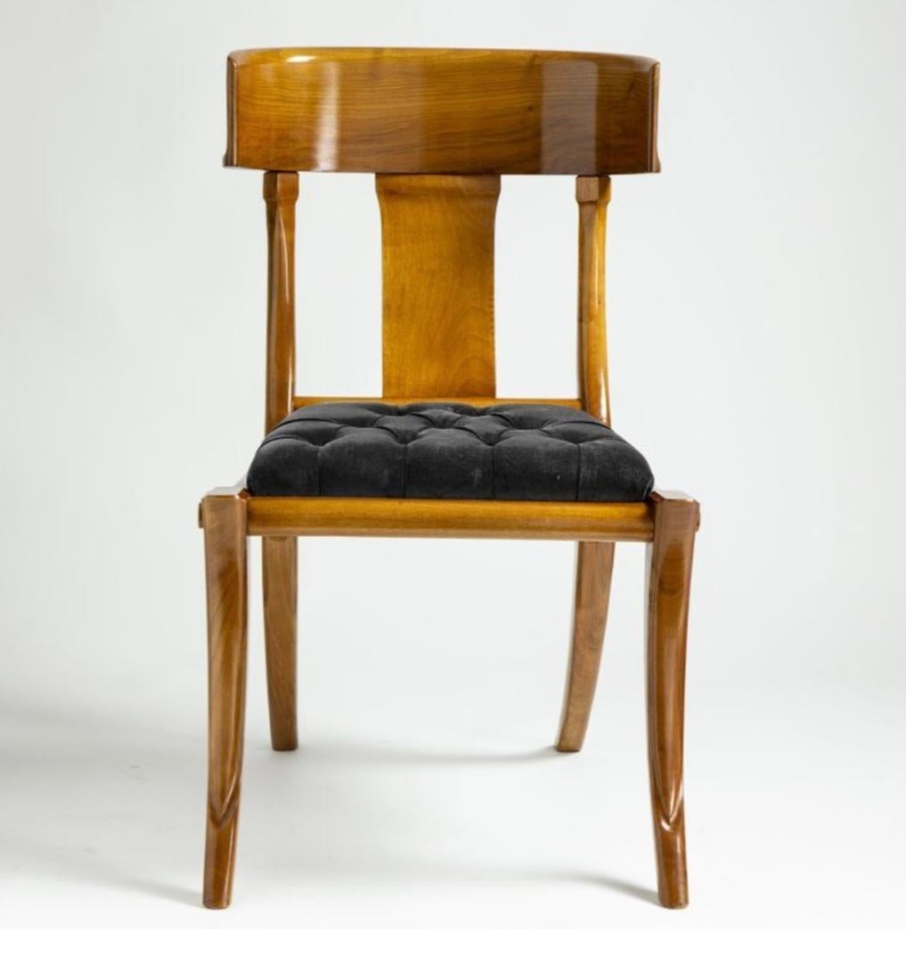 11 chaises et 2 fauteuils klismos en bois de noyer naturel, réalisés avec des coussins en coton blanc.