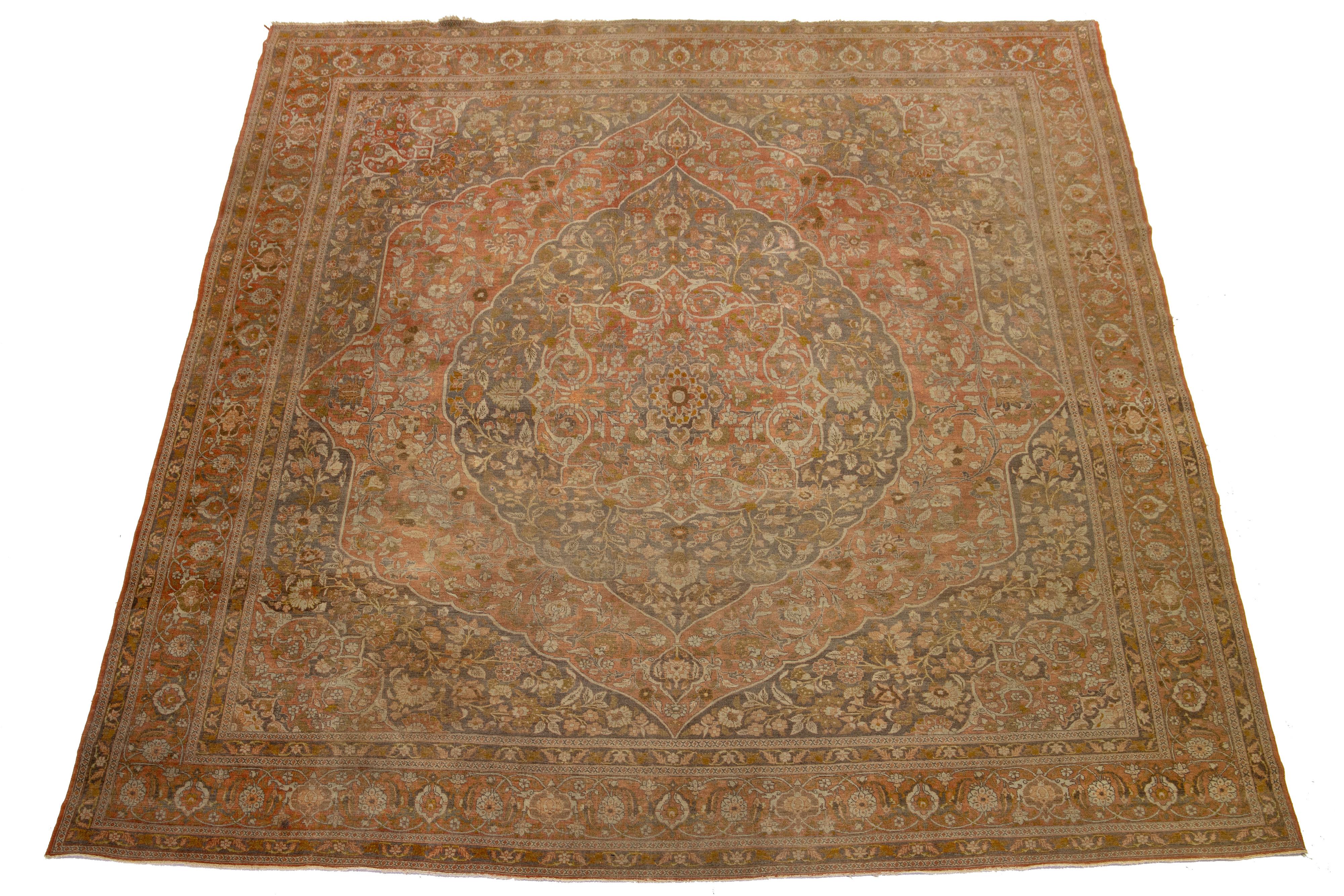 Antique hand-knotted Tabriz wool rug with a rusty field and beige, green, and gray accents in an all-over floral design.

This rug measures 10'7'' x 12'8''.

Our Rugs are professionally cleaned before shipping.