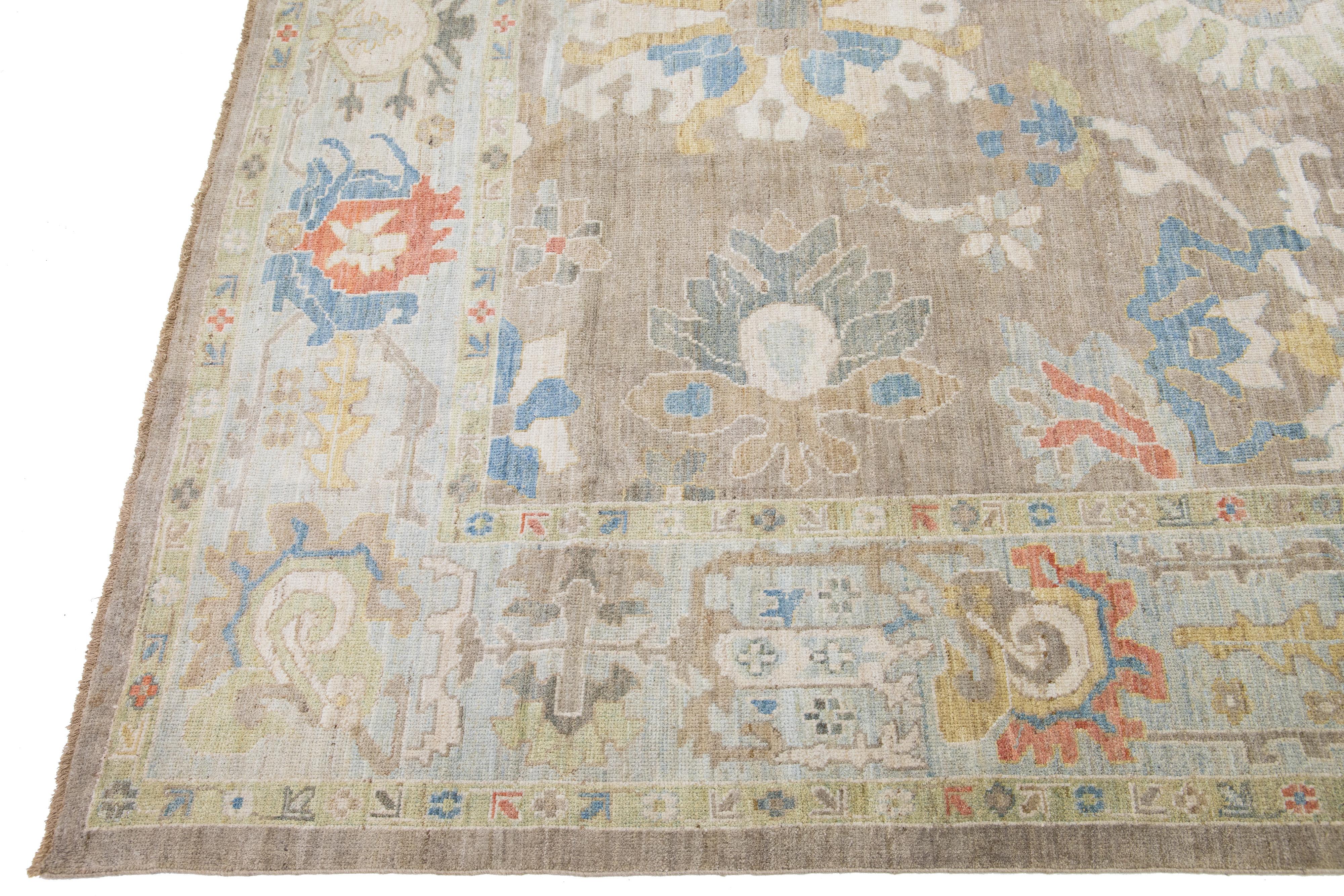 This contemporary sultanabad oriental rug, featuring a central medallion surrounded by symmetrical floral and geometric patterns. The muted palette of beige, soft blue, faded red, and gentle yellow creates a warm, inviting atmosphere that
