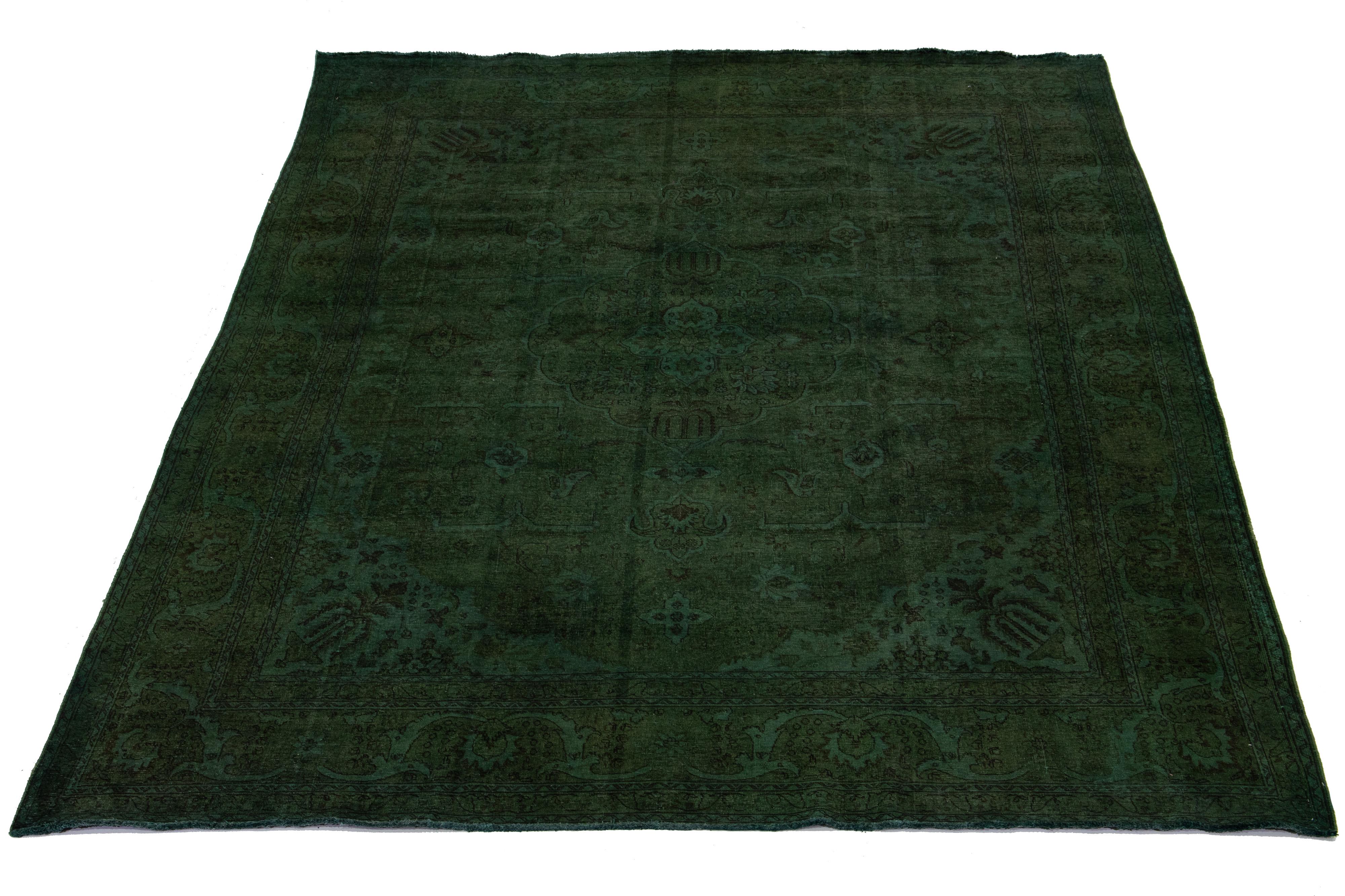 This is an antique hand-knotted wool Persian rug with a green field. It features a medallion floral design with brown accents.

This rug measures 11'2'' x 15'8