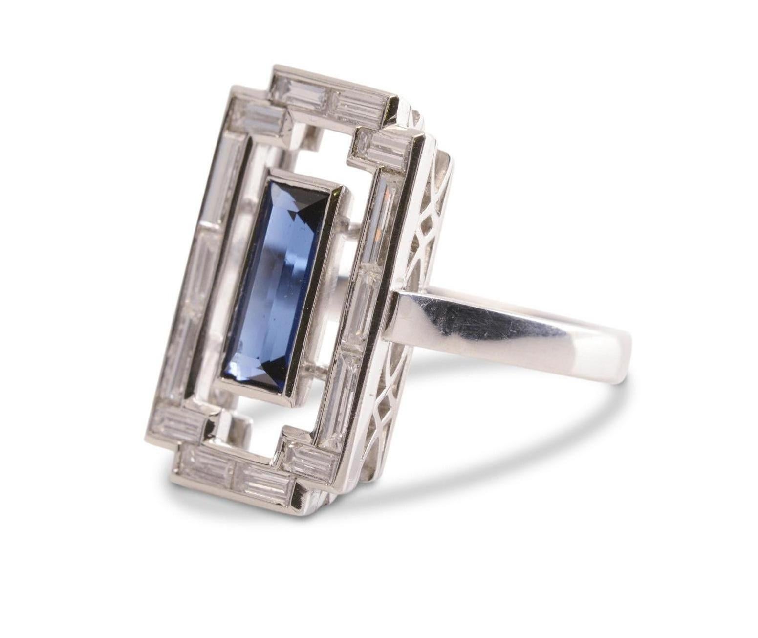 Handcrafted by Nicky Burles in homage to the Art Deco tradition is this striking, platinum tablet ring. A 1.10 carat blue Australian sapphire of the coveted Reddestone creek hue floats in a fine bezel. It's surrounded by a halo set with 14 brilliant