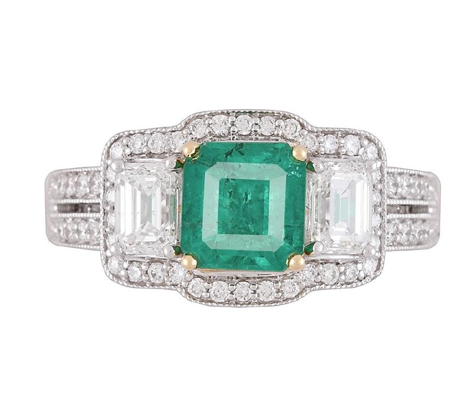 Elevate your style with the mesmerizing beauty of our exquisite ring. At its heart lies a dazzling 1.10 carat cushion-cut Emerald, a gem that symbolizes elegance and timeless allure. This stunning centerpiece is flanked by the brilliance of baguette