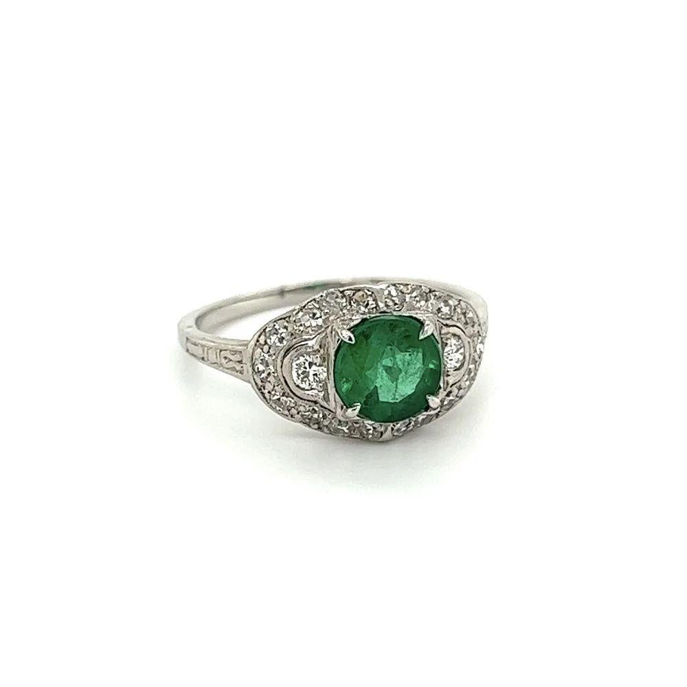 Simply Beautiful! Finely detailed Vintage Art Deco Emerald and Diamond Platinum Cocktail Ring. Centering a securely nestled Hand set 1.10 Carat Round Emerald, artistically surrounded by Diamonds, weighing approx. 0.44tcw. Hand crafted Platinum